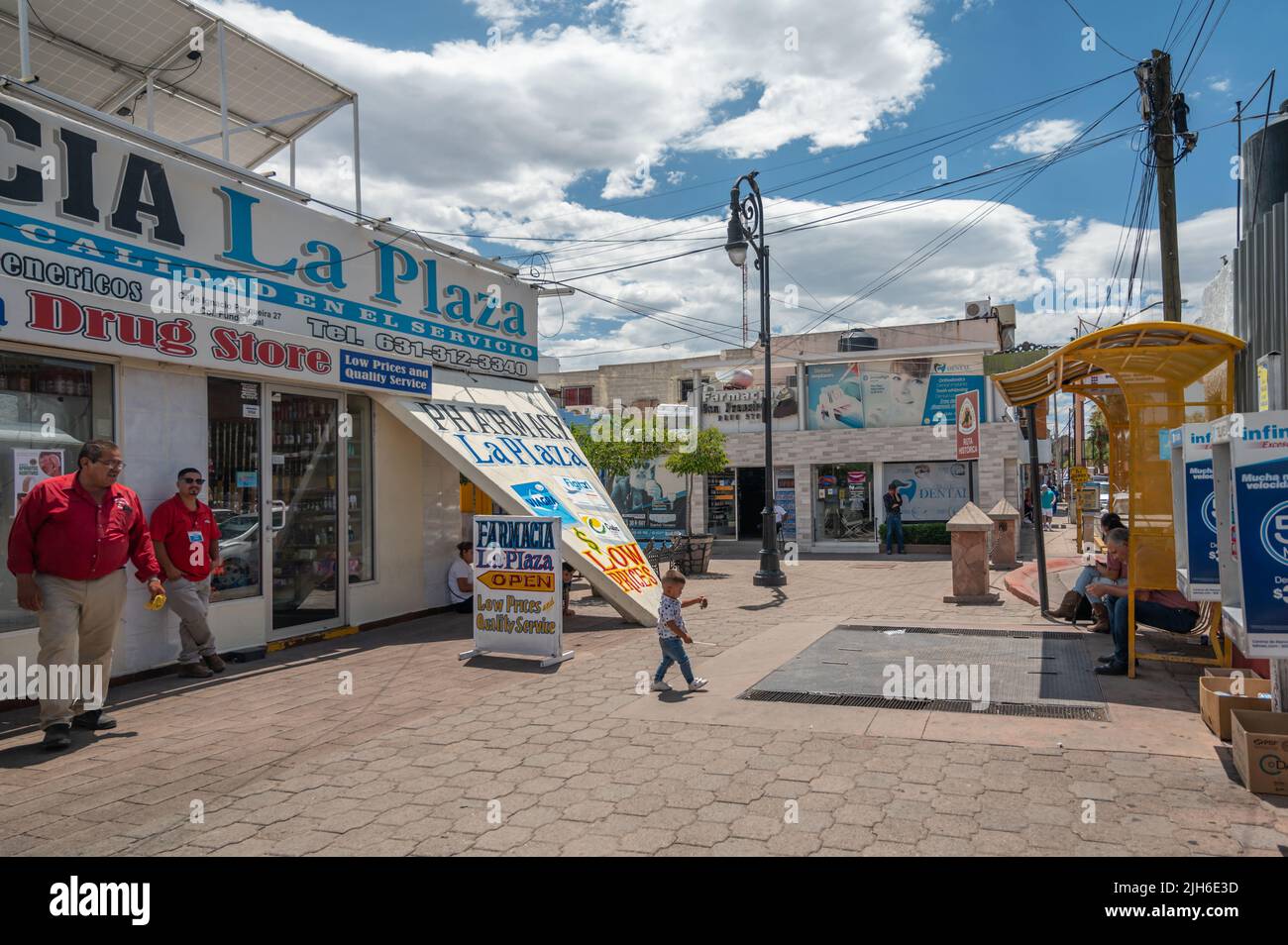 Los empleados esperan fuera de una farmacia en Nogales México para atraer clientes. Foto de stock