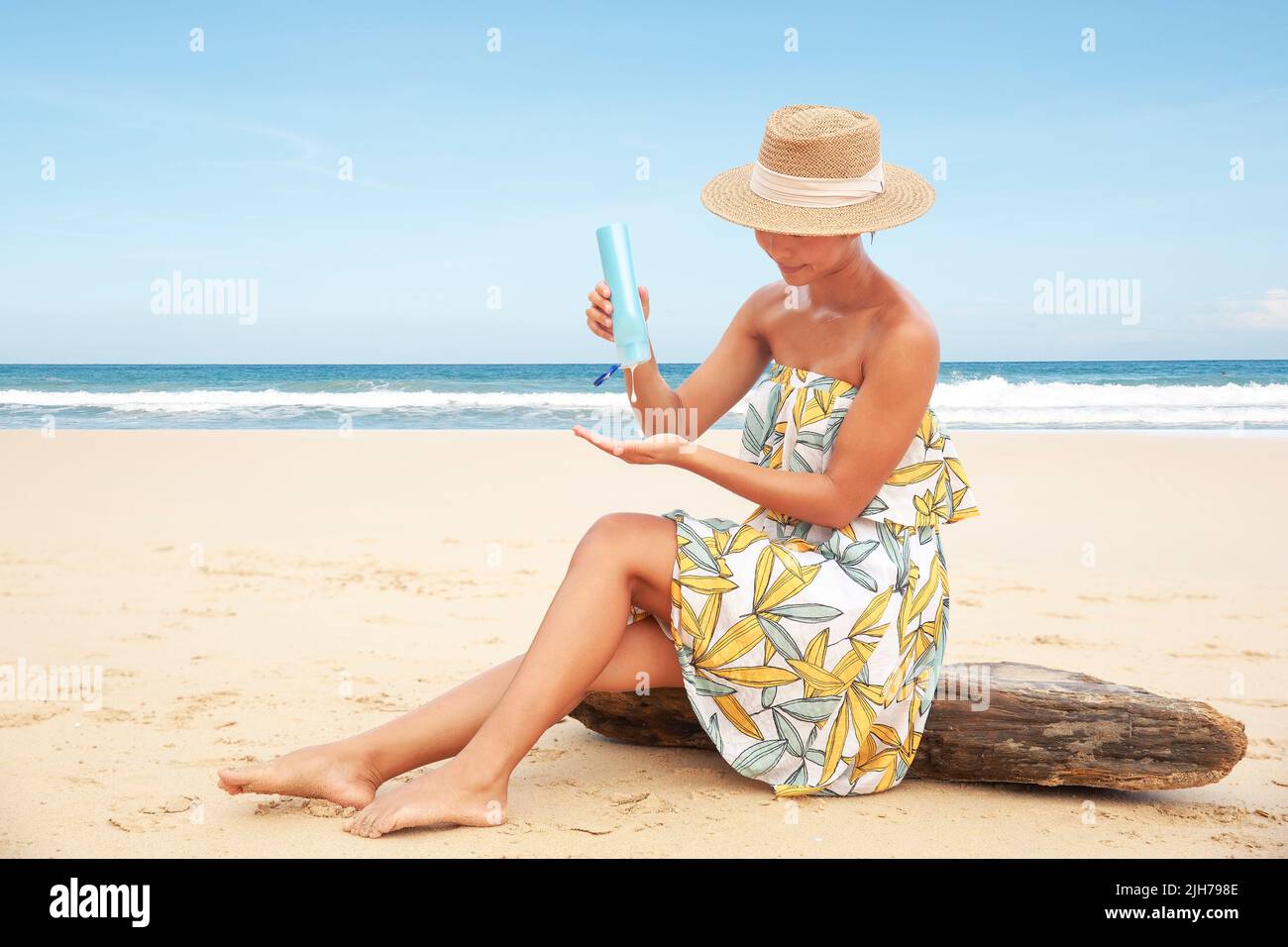 Mujer vertiendo aplicando crema protectora solar en la playa para protección solar de amplio espectro UVA, UVB Foto de stock