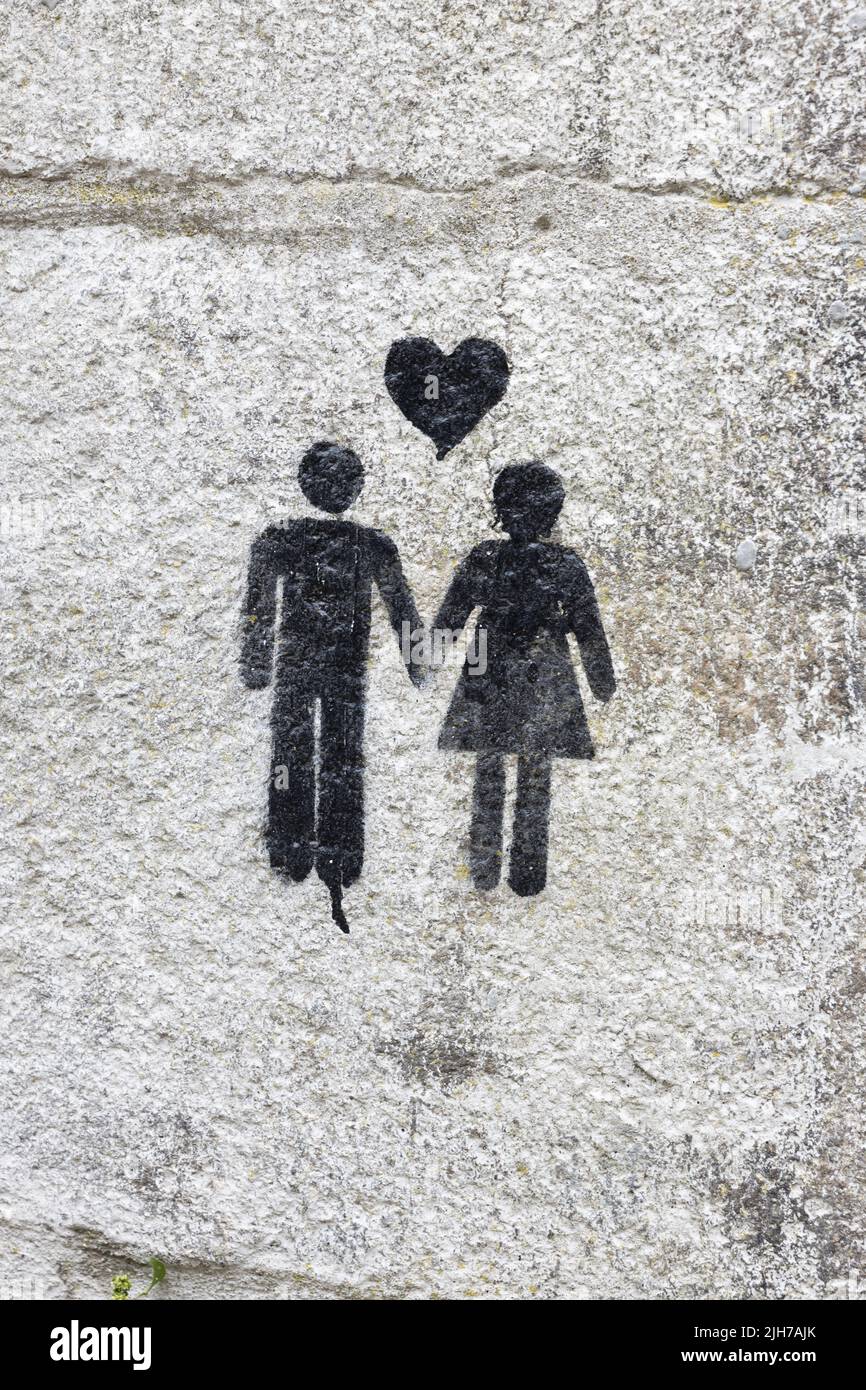 Amor Graffiti. Un hombre y una mujer tomando las manos con un corazón entre ellos Foto de stock
