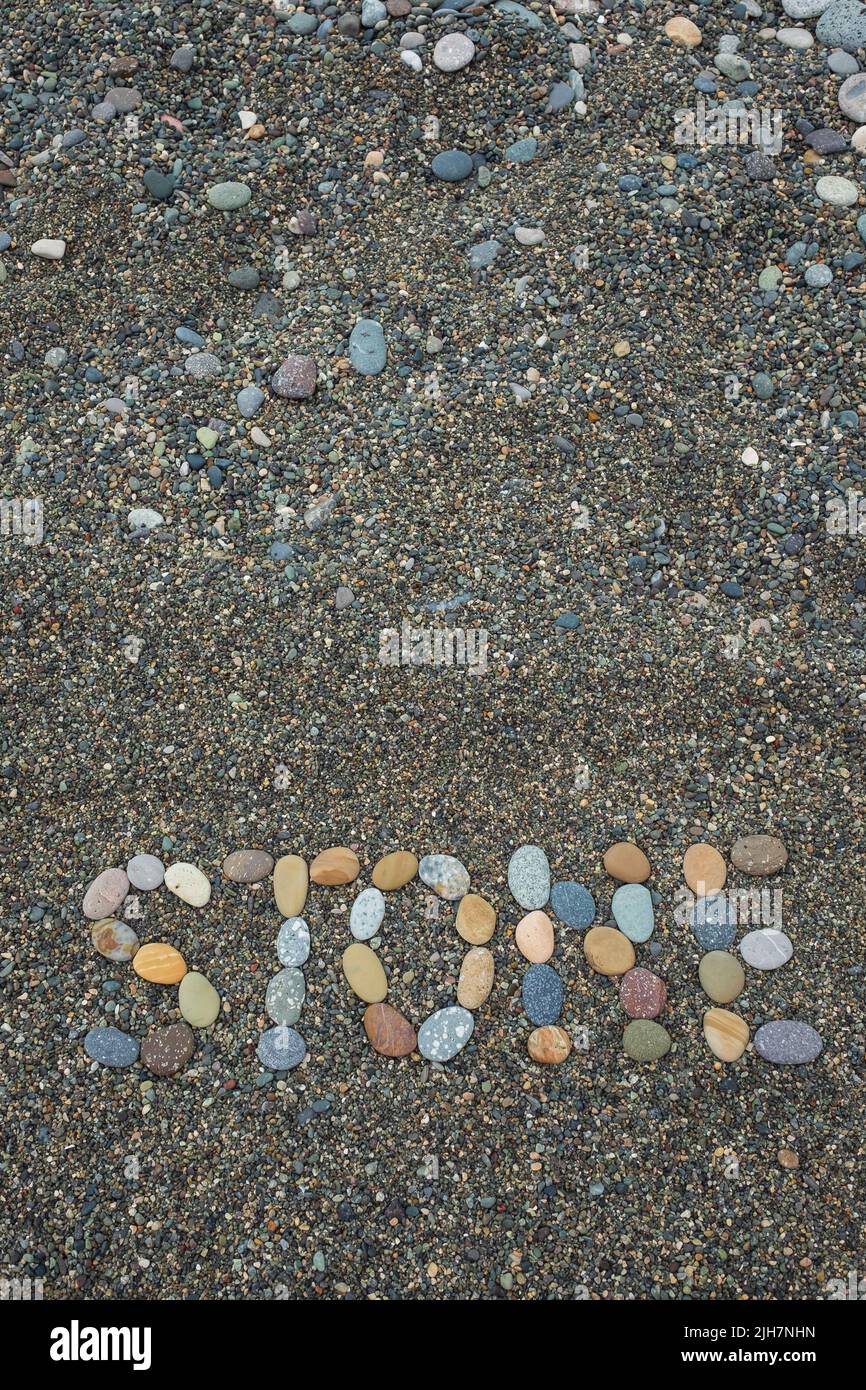 Texto piedra hecha de piedras en la playa de arena. Vista superior Foto de stock