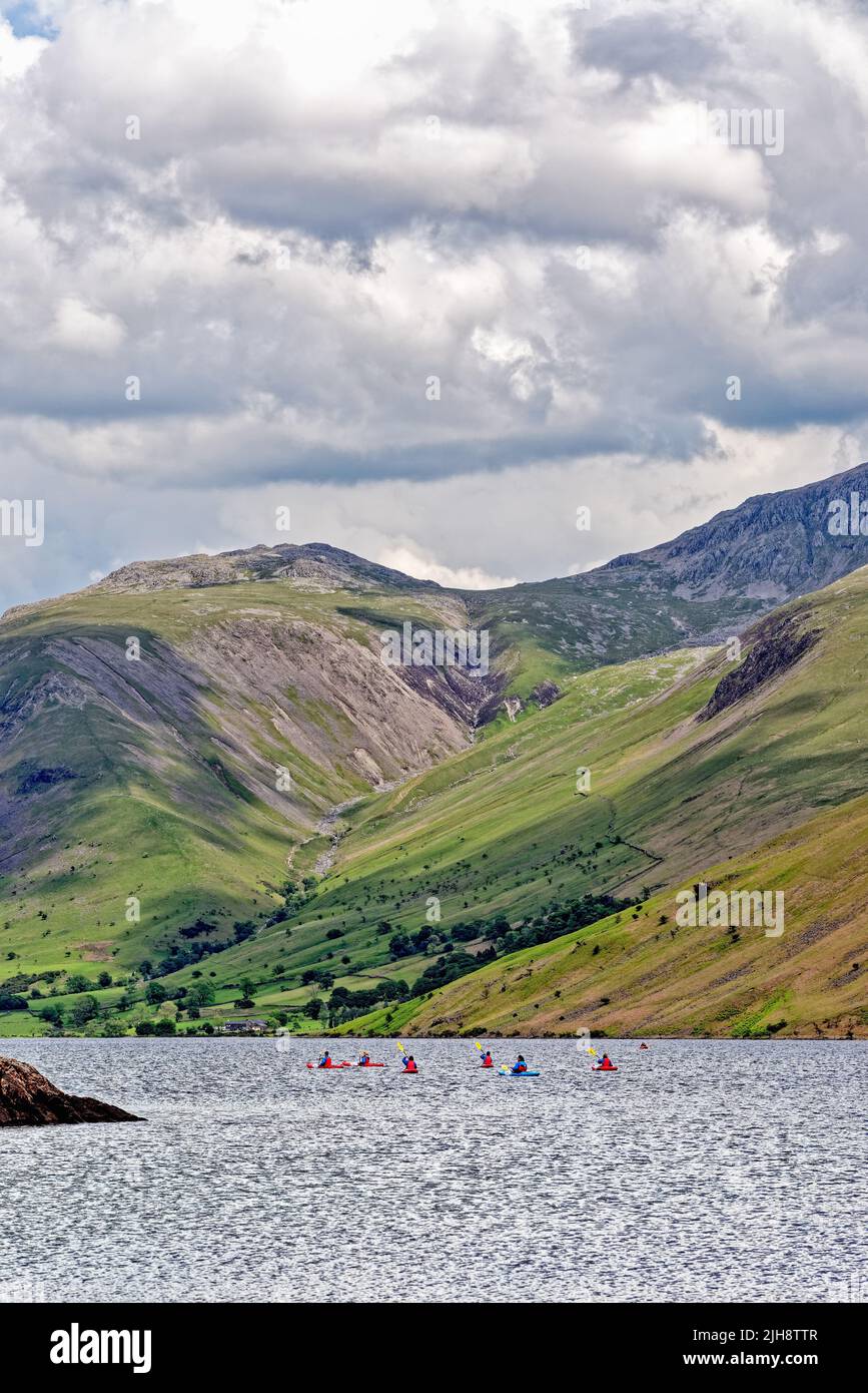 Canoistas en el lago Waster, en un día de verano, con el espectacular paisaje escarpado en el fondo Wasdale Cumbria Inglaterra Reino Unido Foto de stock