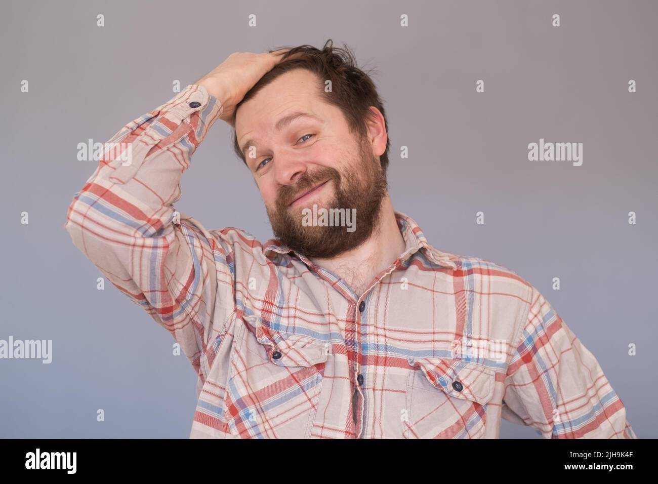 Orgulloso hombre caucásico maduro con barba satisfecha con los resultados de su trabajo aislados sobre fondo azul Foto de stock