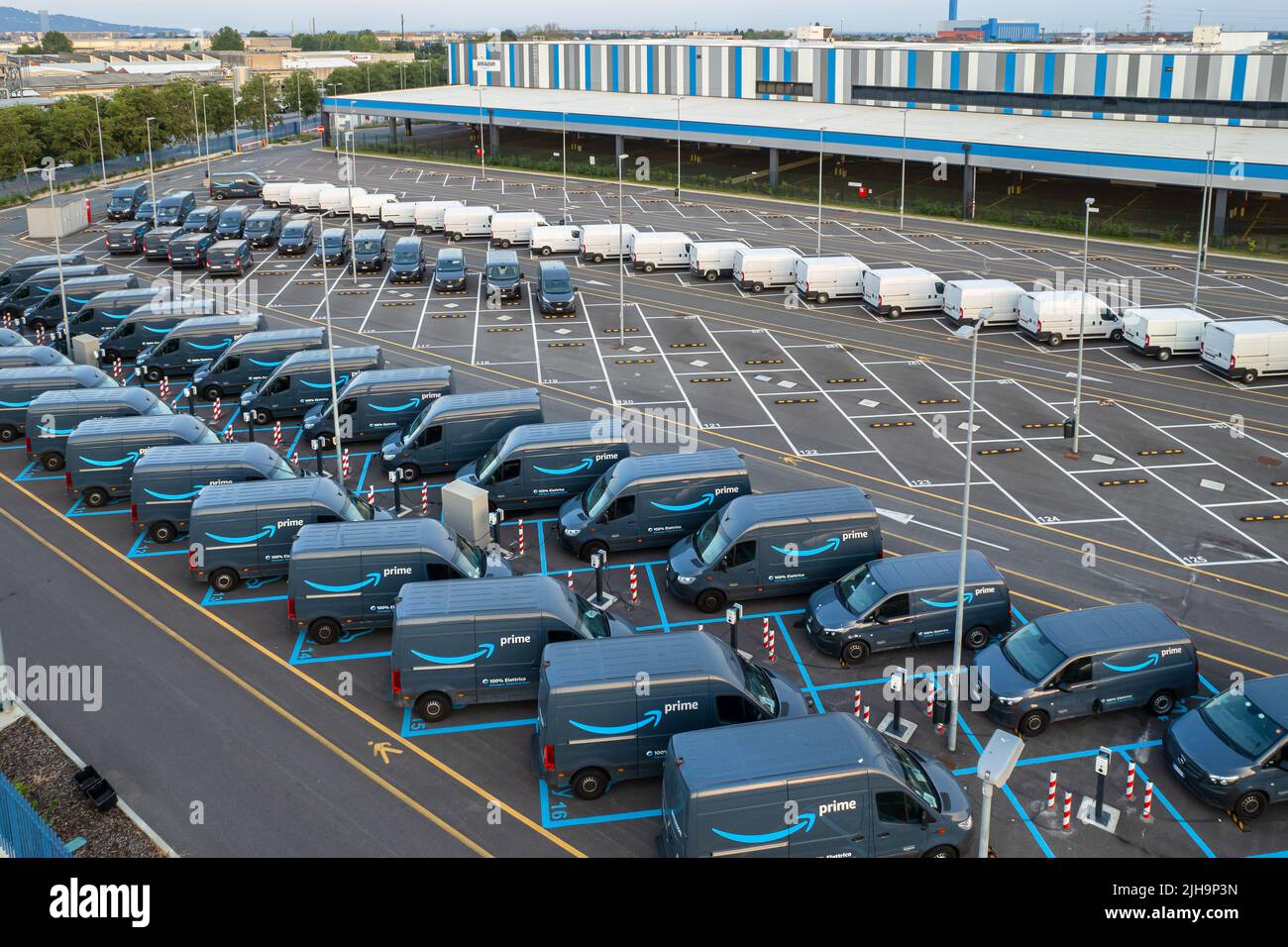 Vista superior de las furgonetas eléctricas de Amazon Prime, estacionadas en el centro logístico de Amazon. Turín, Italia - Julio de 2022 Foto de stock