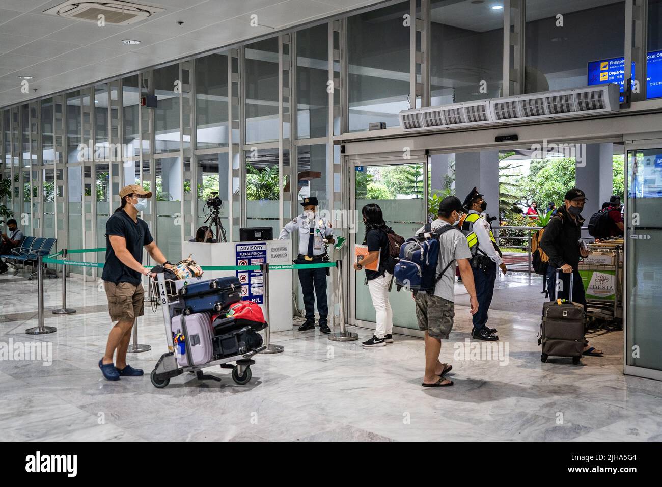 Manila, Filipinas. 17 de julio de 2022. Los viajeros internacionales pasan por los puntos de control de seguridad y temperatura corporal en el Aeropuerto Internacional Manila Ninoy Aquino (MNL). Los viajes internacionales continúan en medio de un aumento mundial de las infecciones por COVID a partir de la variante BA.5 altamente contagiosa, que llevó a algunos países a revertir los requisitos de viaje de la era pandémica, incluidos los mandatos de máscara y los requisitos de vacunas actualizados para incluir inyecciones de refuerzo para la entrada sin visado. Matt Hunt / Neato Crédito: Matt Hunt / Neato / Alamy Live News Foto de stock