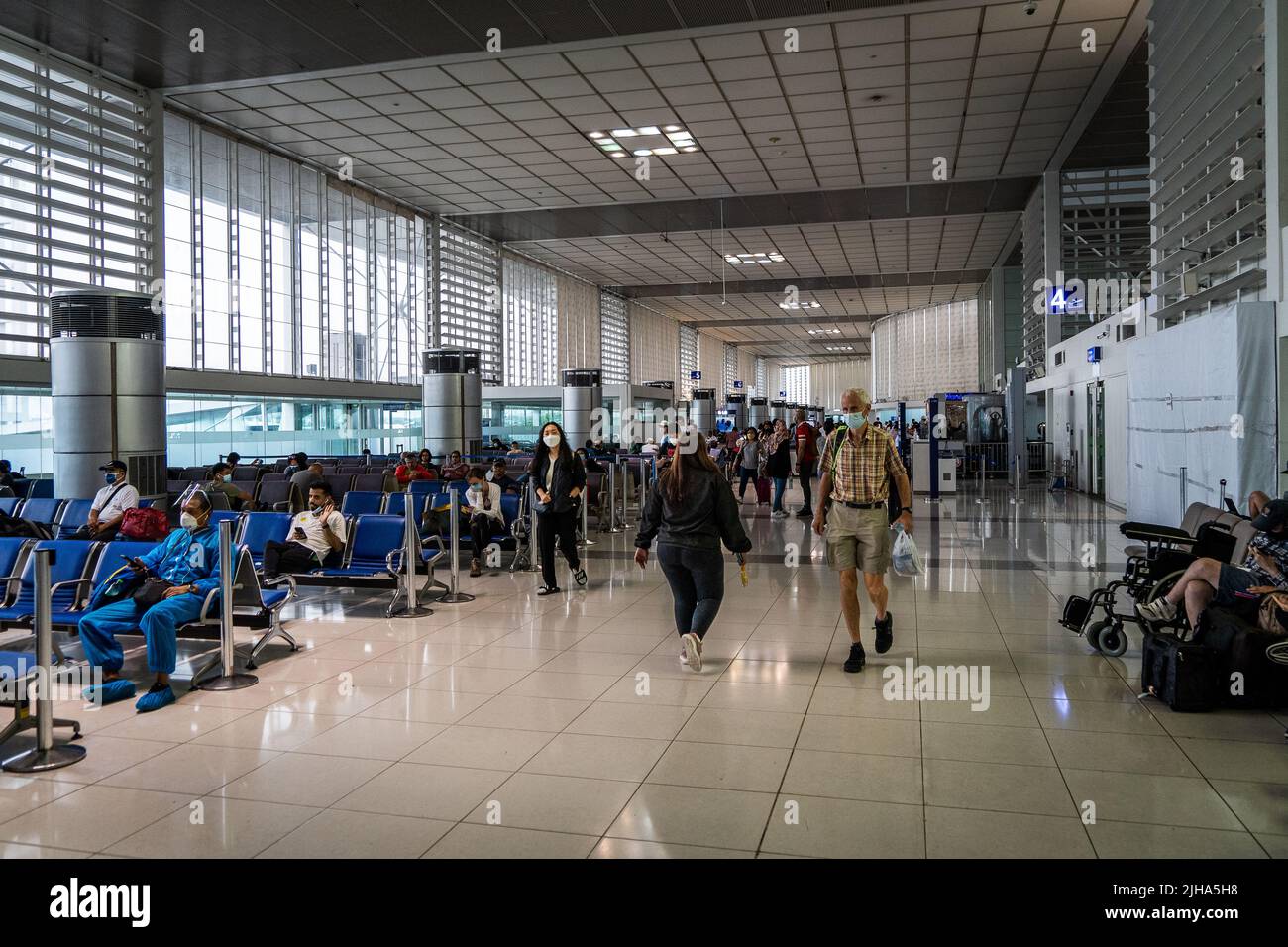 Manila, Filipinas. 17 de julio de 2022. Los viajeros pasan por las puertas de embarque en la terminal de salidas internacionales del Aeropuerto Internacional Manila Ninoy Aquino (MNL). Los viajes internacionales continúan en medio de un aumento mundial de las infecciones por COVID a partir de la variante BA.5 altamente contagiosa, que llevó a algunos países a revertir los requisitos de viaje de la era pandémica, incluidos los mandatos de máscara y los requisitos de vacunas actualizados para incluir inyecciones de refuerzo para la entrada sin visado. Matt Hunt / Neato Crédito: Matt Hunt / Neato / Alamy Live News Foto de stock