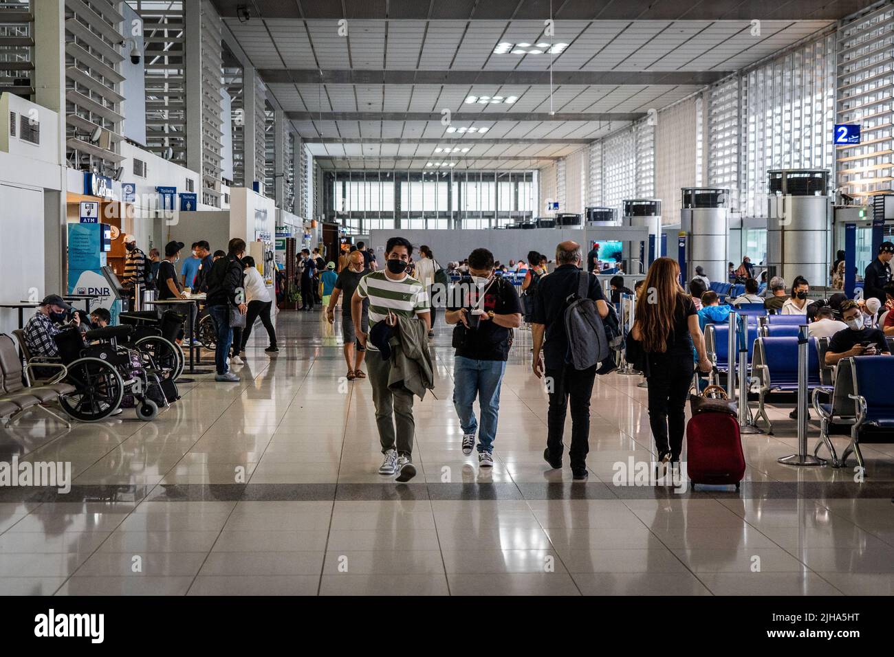 Manila, Filipinas. 17 de julio de 2022. Los viajeros pasan por las puertas de embarque en la terminal de salidas internacionales del Aeropuerto Internacional Manila Ninoy Aquino (MNL). Los viajes internacionales continúan en medio de un aumento mundial de las infecciones por COVID a partir de la variante BA.5 altamente contagiosa, que llevó a algunos países a revertir los requisitos de viaje de la era pandémica, incluidos los mandatos de máscara y los requisitos de vacunas actualizados para incluir inyecciones de refuerzo para la entrada sin visado. Matt Hunt / Neato Crédito: Matt Hunt / Neato / Alamy Live News Foto de stock