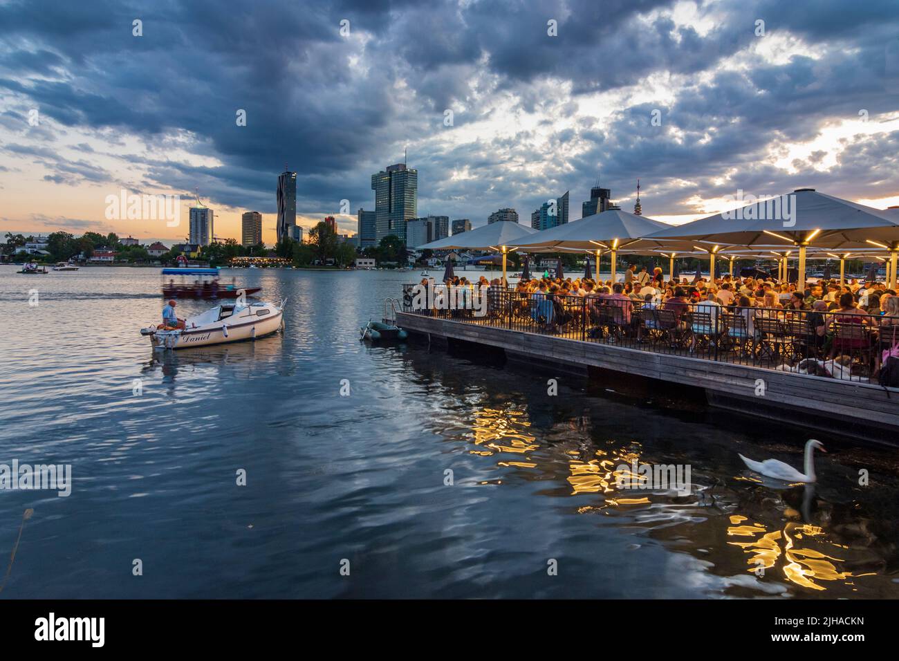 Viena, Viena: Lago oxbow Alte Donau (Danubio antiguo), puesta de sol, restaurante flotante Strandcafe, Donaucity con la torre DC 1 y la torre IZD, Donauturm (Danubio T Foto de stock