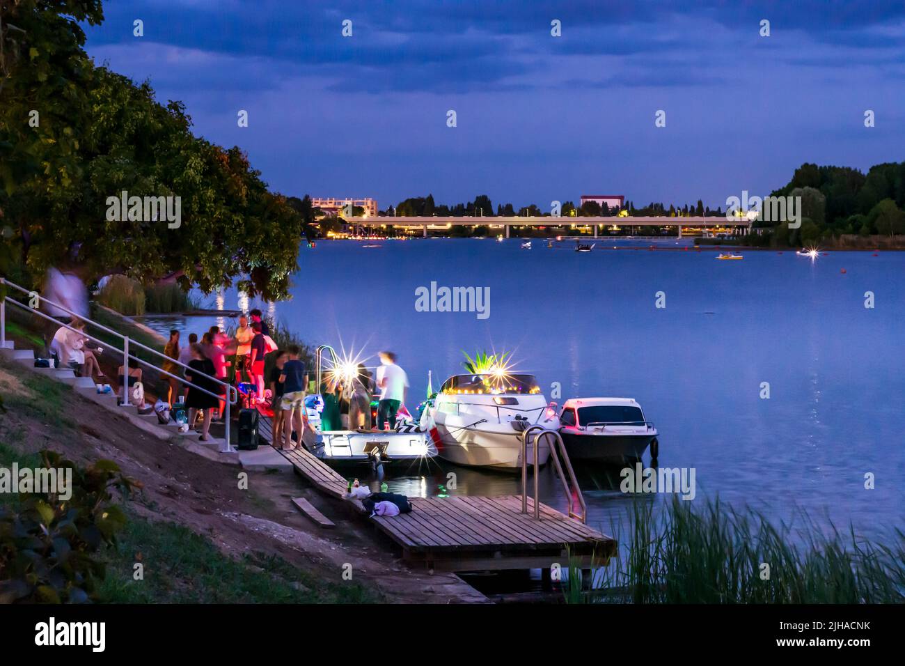 Viena: Lago oxbow Alte Donau (Danubio antiguo), puesta de sol, fiesta privada en los barcos en 22. Donaustadt, Viena, Austria Foto de stock