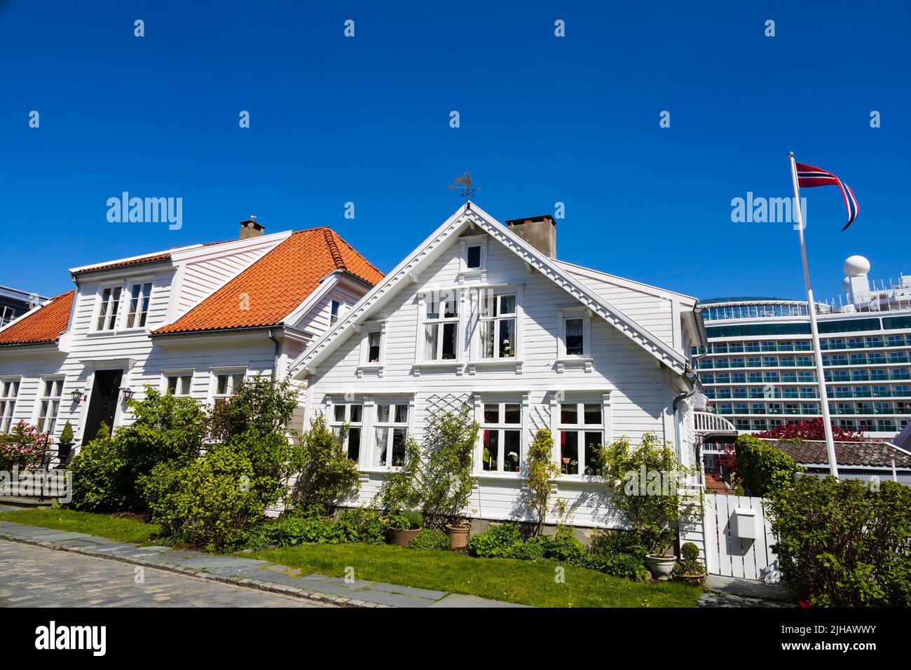 Casas tradicionales noruegas pintadas en madera blanca en Øvre Strandgate, Stavanger, Noruega. El crucero de P&O, MS Iona, está en el fondo. Foto de stock
