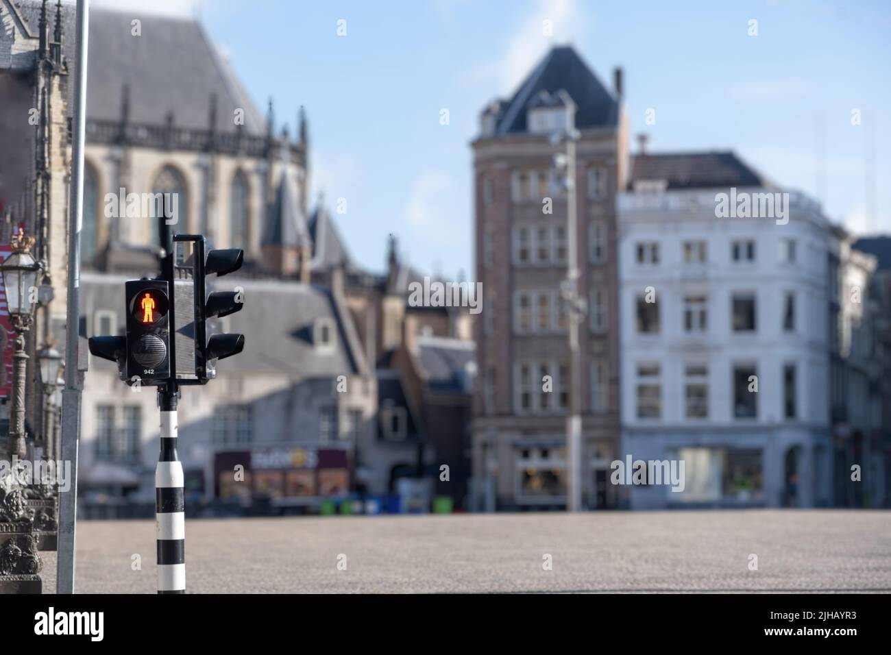 Semáforos rojos para peatones en la ciudad de Ámsterdam, difuminan el icónico fondo de la casa. Semáforo, señal de advertencia en el cruce peatonal, Holanda, Países Bajos. Foto de stock
