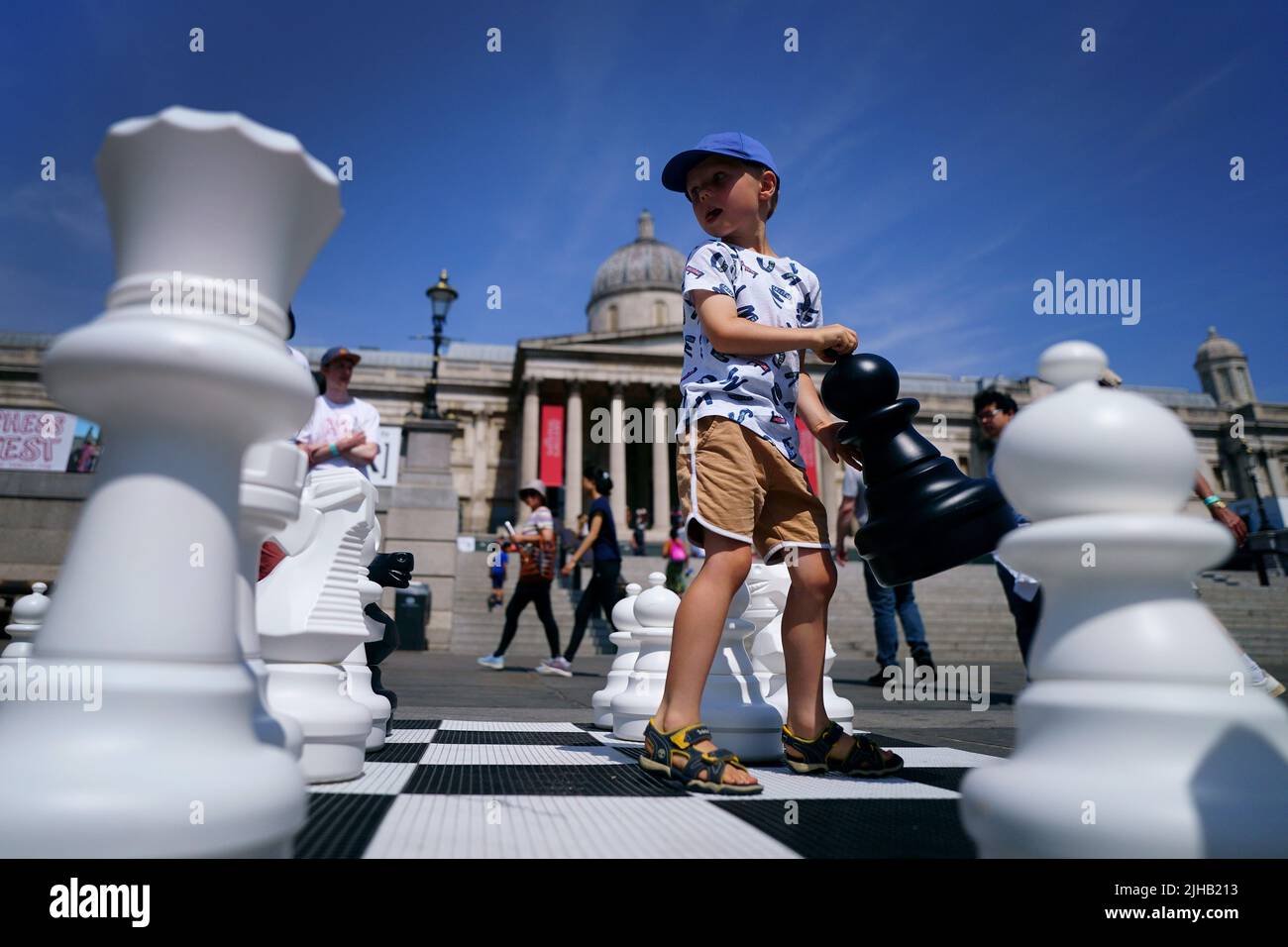 Finn Moriarty, de 5 años, mueve piezas de ajedrez gigantes durante ChessFest, el evento de ajedrez de un día más grande del Reino Unido, en Trafalgar Square, en el centro de Londres. Fecha de la foto: Domingo 17 de julio de 2022. Foto de stock
