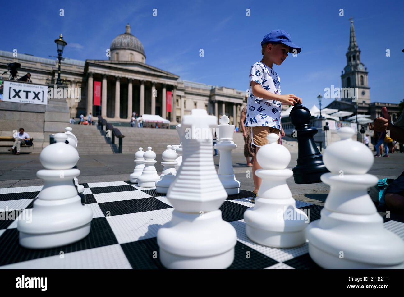 Finn Moriarty, de 5 años, mueve piezas de ajedrez gigantes durante ChessFest, el evento de ajedrez de un día más grande del Reino Unido, en Trafalgar Square, en el centro de Londres. Fecha de la foto: Domingo 17 de julio de 2022. Foto de stock