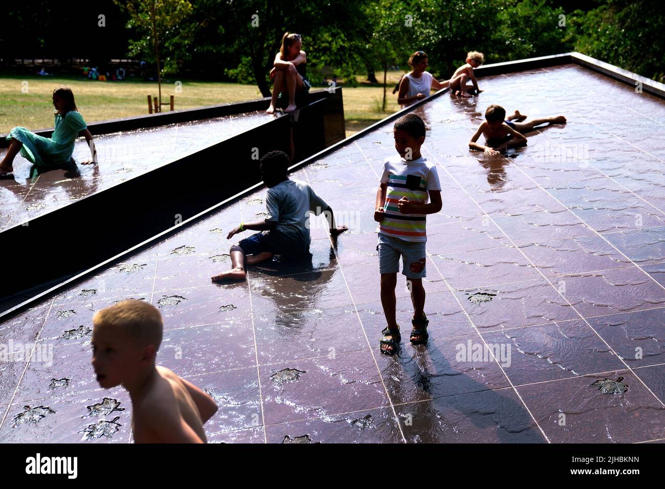 Los niños pequeños juegan en la fuente Canada Memorial durante el clima cálido en Green Park, en el centro de Londres. Se prevé que las temperaturas alcancen los 31C grados en toda Inglaterra central el domingo, antes de los máximos históricos la próxima semana. Fecha de la foto: Domingo 17 de julio de 2022. Foto de stock