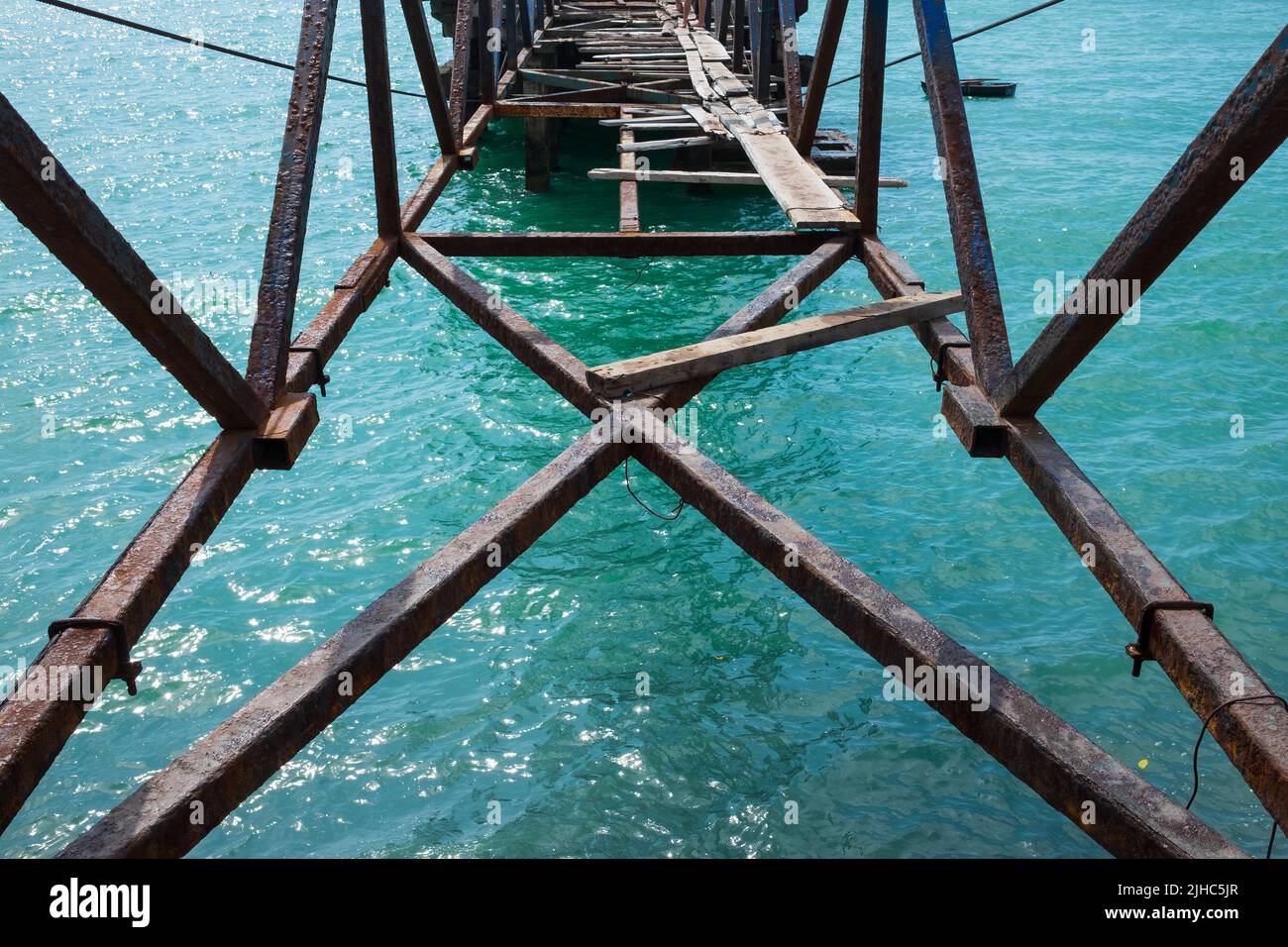 puente roto sobre el río o el mar. Vista en agujero y agua azul Foto de stock