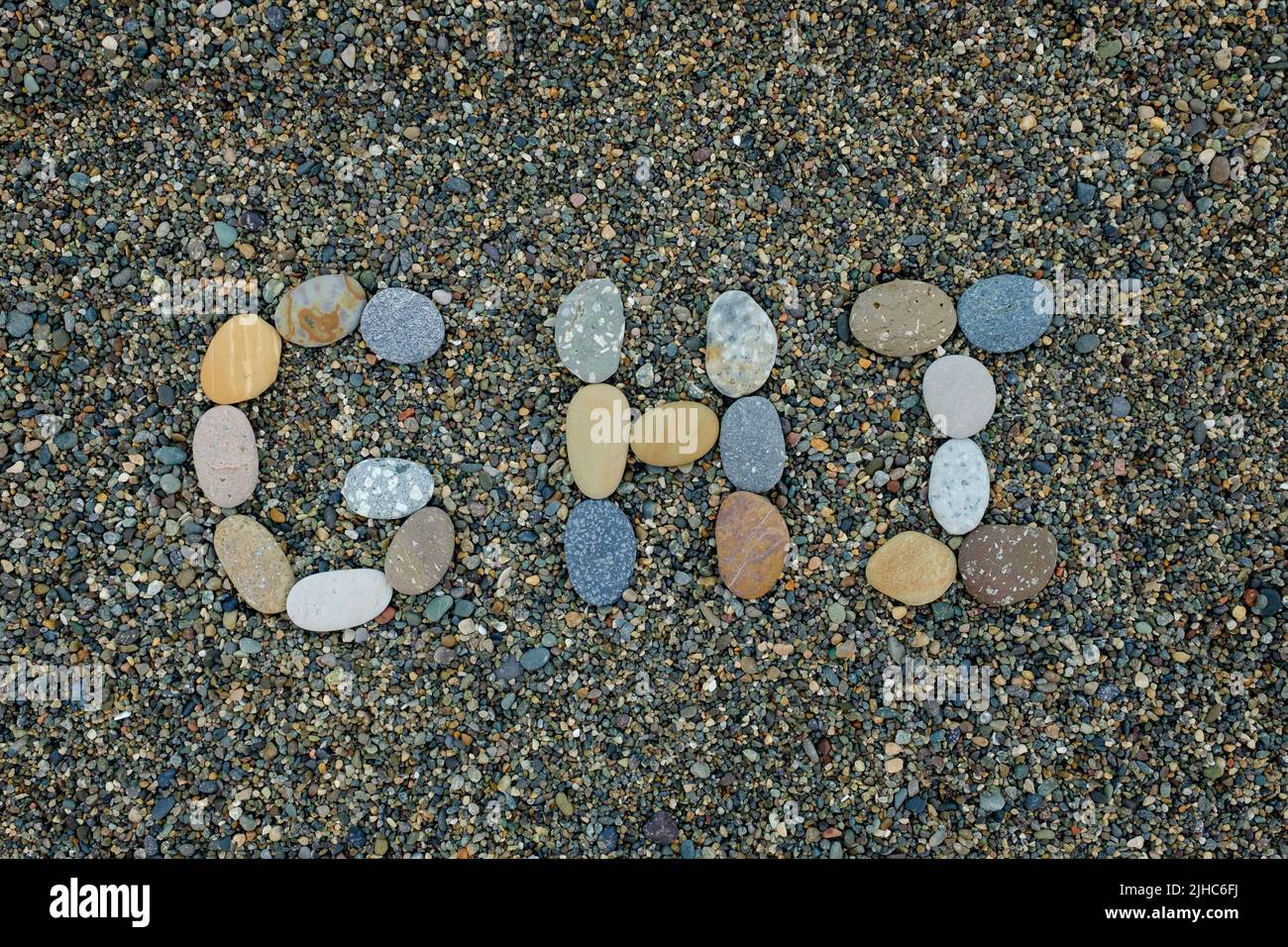 letras del alfabeto g h hice de piedras en la arena de la playa Foto de stock