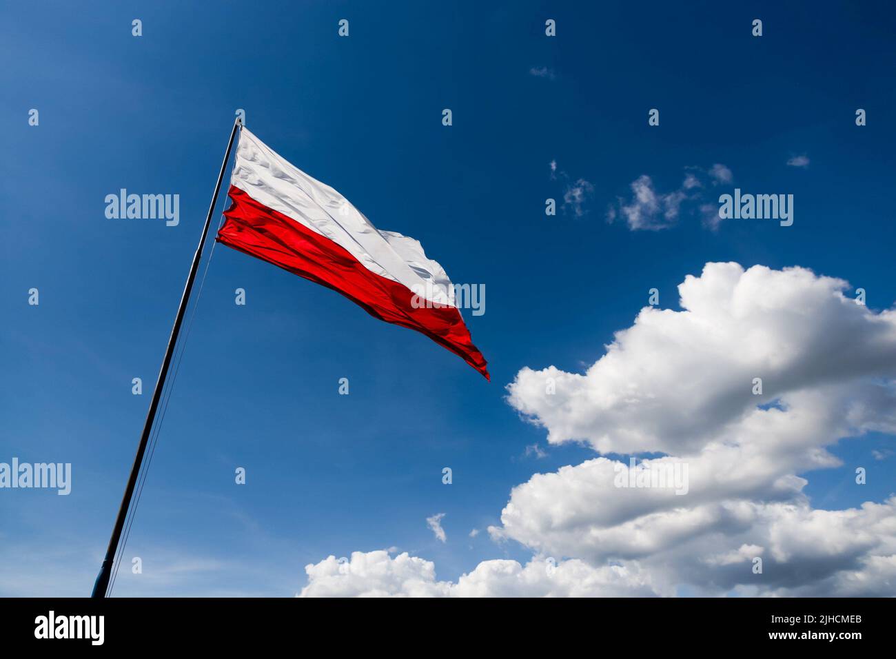 La bandera roja y blanca de Polonia ondea al viento Foto de stock