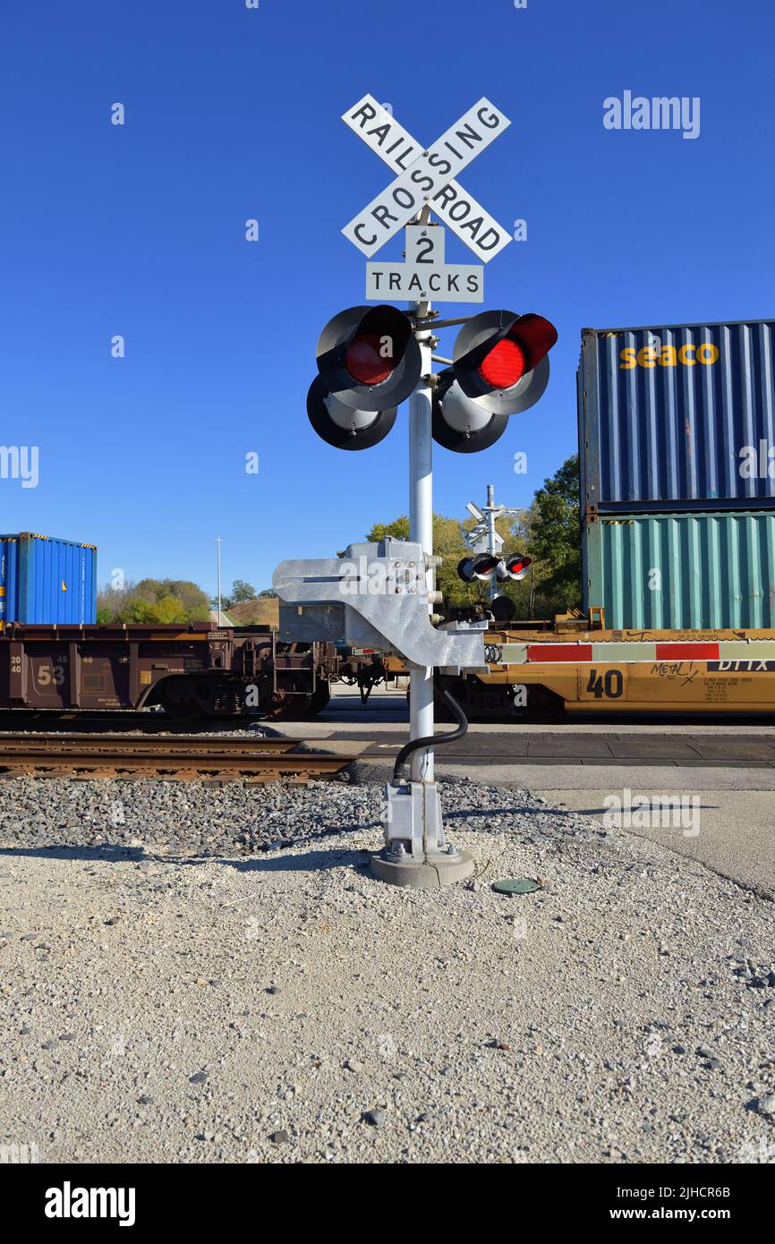 Hoffman Estates, Illinois, EE.UU. Señales intermitentes en un cruce de grado de ferrocarril protegido por el dispositivo como un tren de carga intermodal pasa. Foto de stock