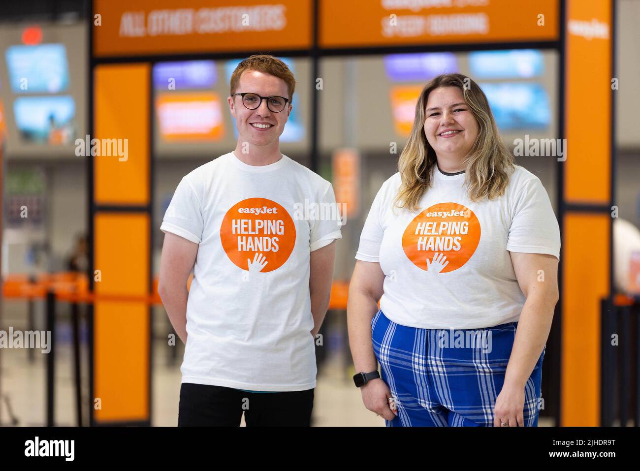 Callum Whyman y Cleo Greaves, asistentes de atención al cliente de easyJet, lanzan la nueva línea de atención al cliente familiar de la aerolínea en el aeropuerto de Luton. Fecha de emisión: Lunes 18 de julio de 2022. Foto de stock