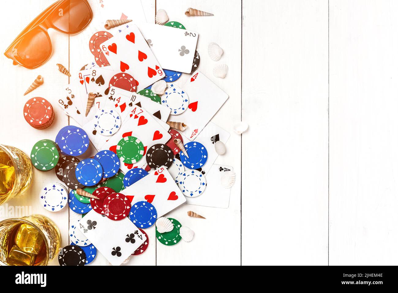 Juegos azar. Fichas de póquer, gafas de sol y chanclas sobre una mesa blanca. Vista superior. CopySpace. Póquer. Verano. Llamarada del sol Fotografía de stock - Alamy
