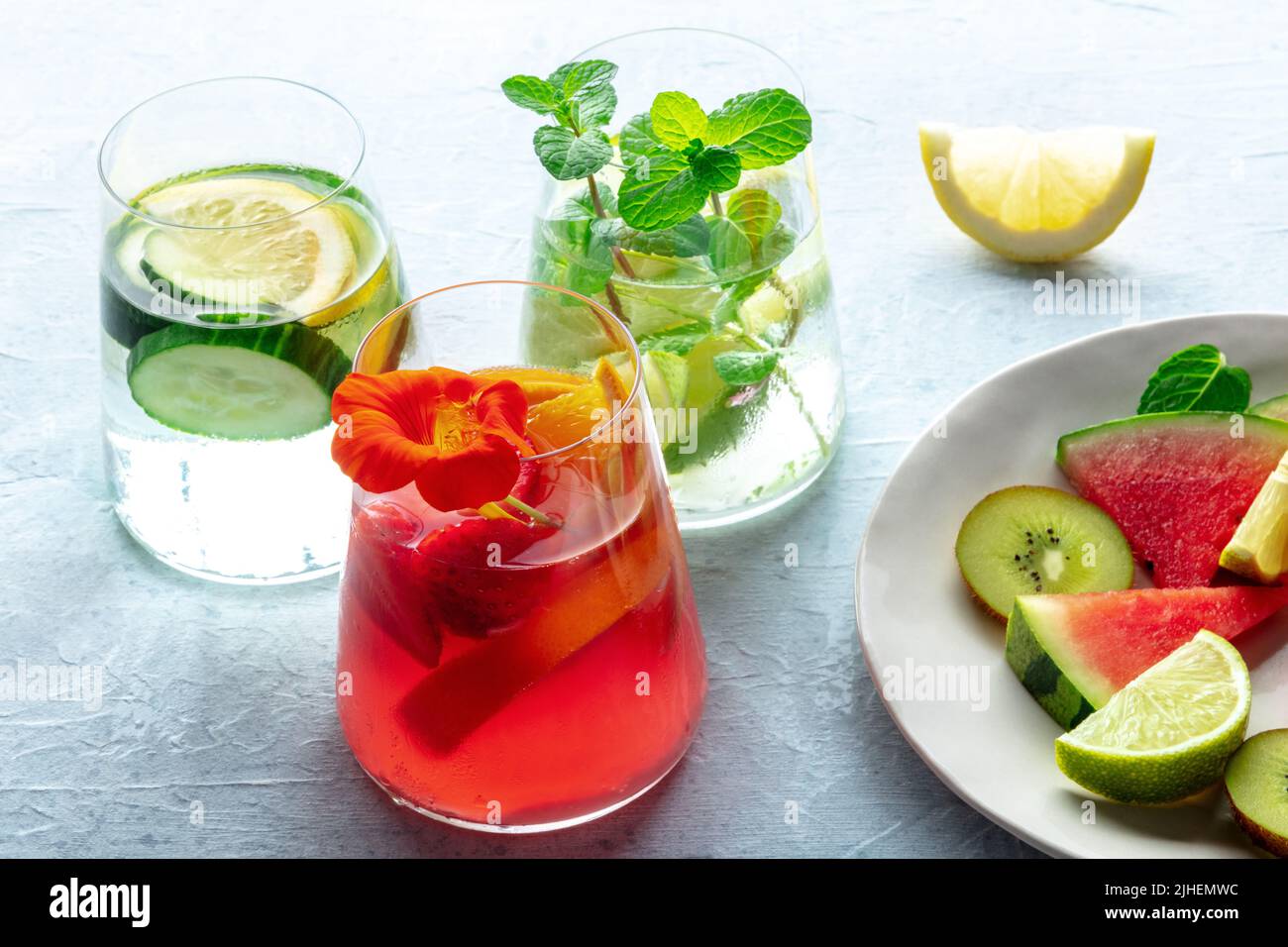 Cócteles de verano. Bebidas frías con fruta fresca. Sin alcohol saludable. Limonadas de cítricos, fresa y pepino Foto de stock