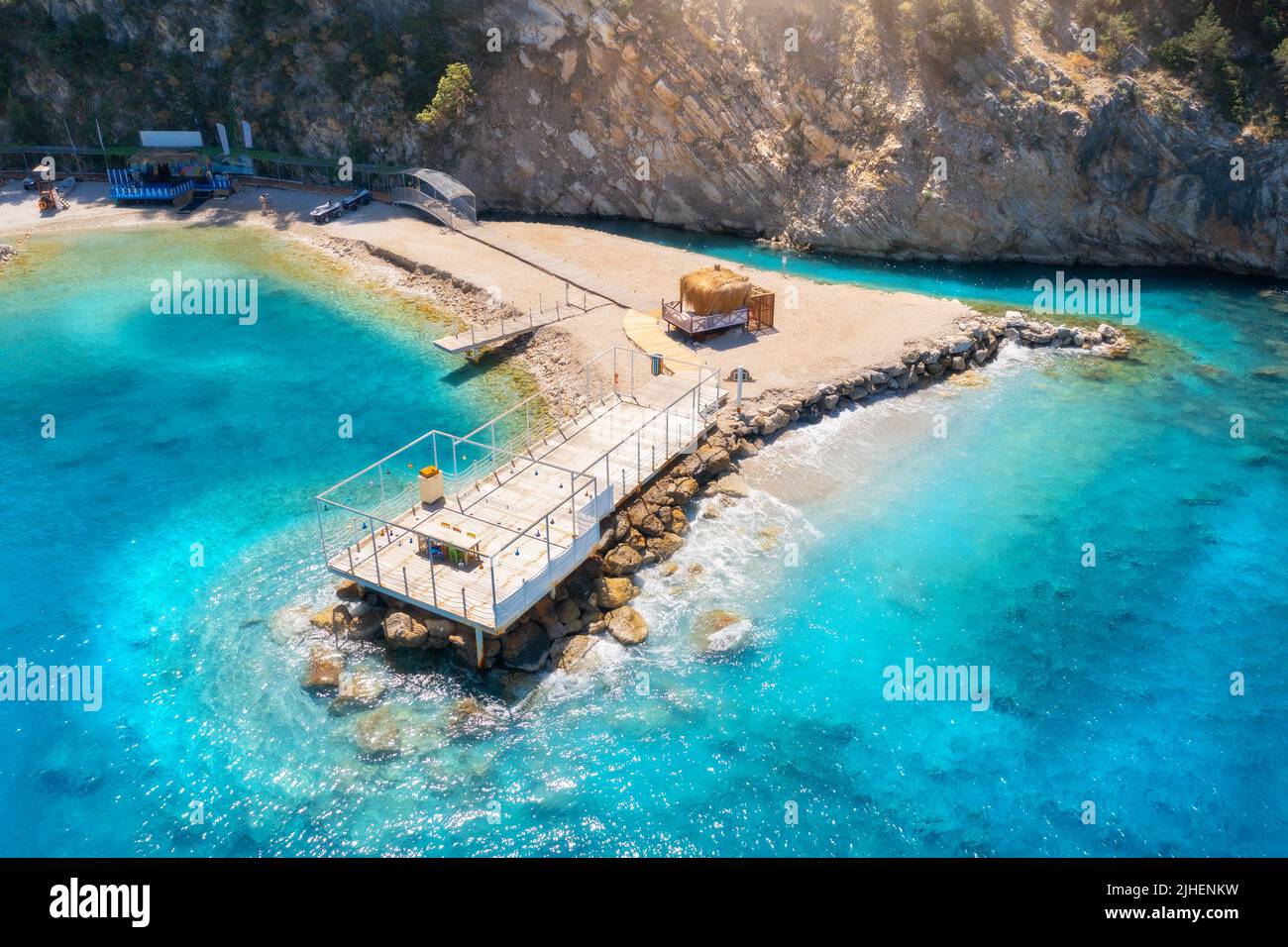 Vista aérea de hermoso muelle de madera, bahía de mar, playa de arena Foto de stock