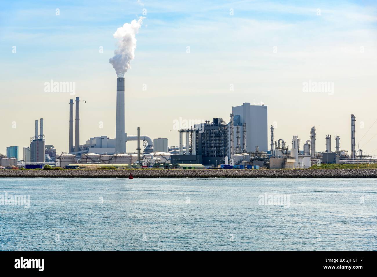 Vista de una refinería de petróleo junto al puerto en un soleado día de verano Foto de stock