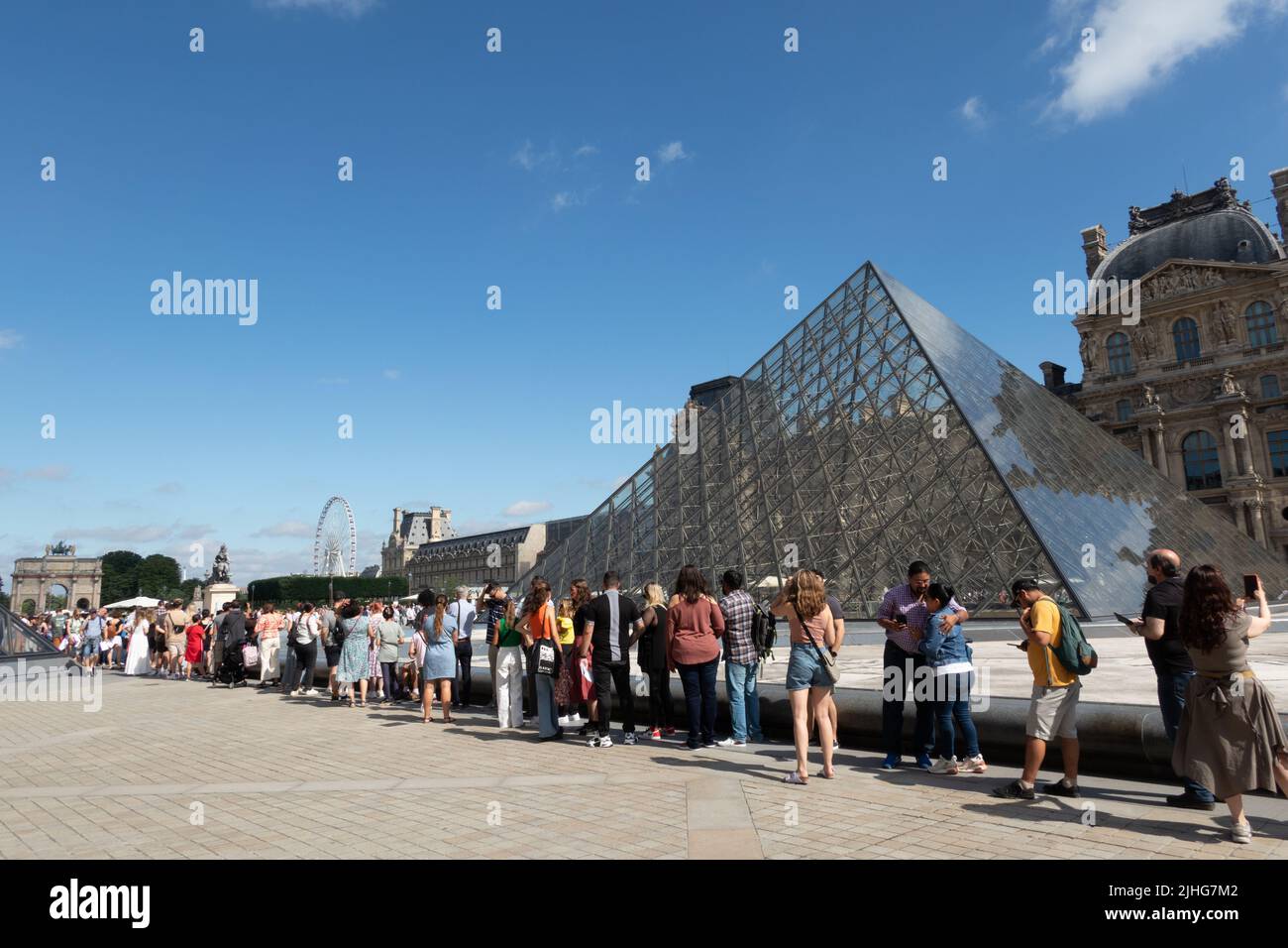 Personas en línea esperando entrar en el Museo del Louvre En París Foto de stock