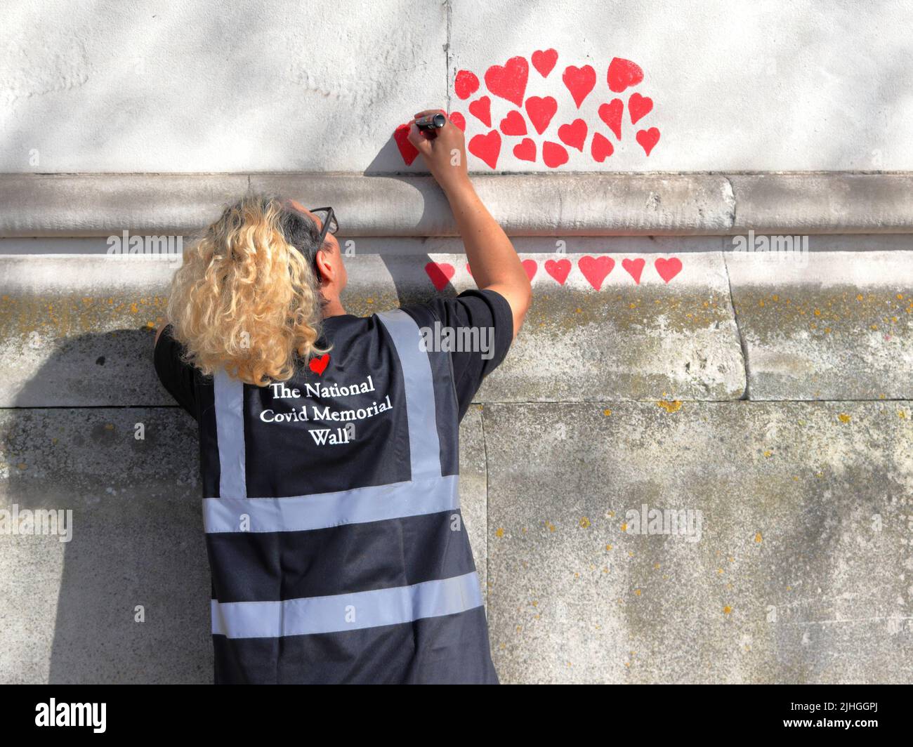 Londres, Reino Unido - 30 de marzo de 2021: El Muro Conmemorativo Nacional de Covid, voluntarios pintando 150.000 corazones rojos para conmemorar las muertes de Covid-19 Foto de stock