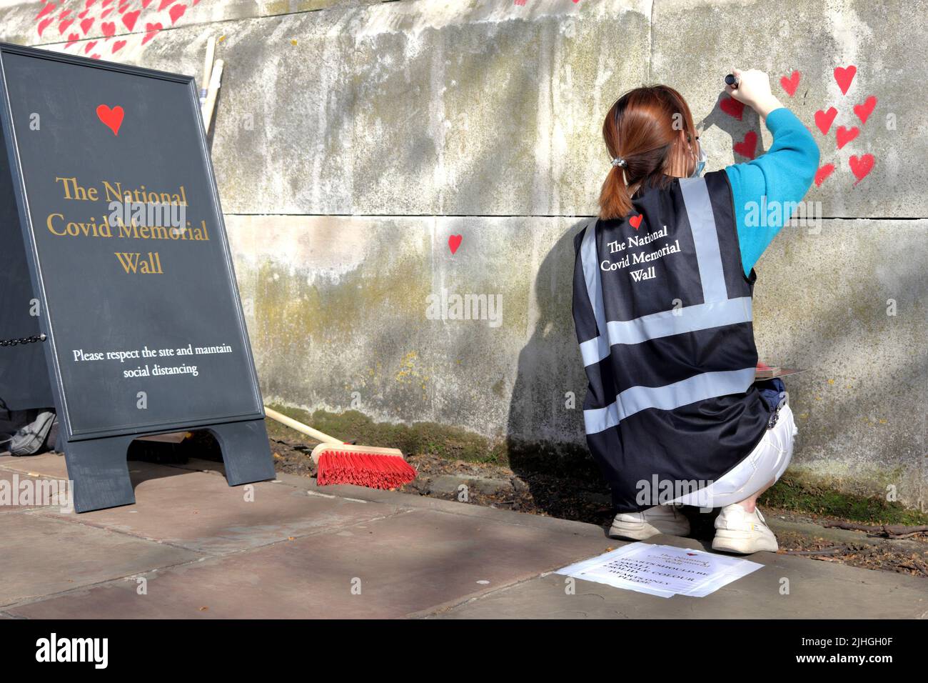 Londres, Reino Unido - 30 de marzo de 2021: El Muro Conmemorativo Nacional de Covid, voluntarios pintando 150.000 corazones rojos para conmemorar las muertes de Covid-19 Foto de stock