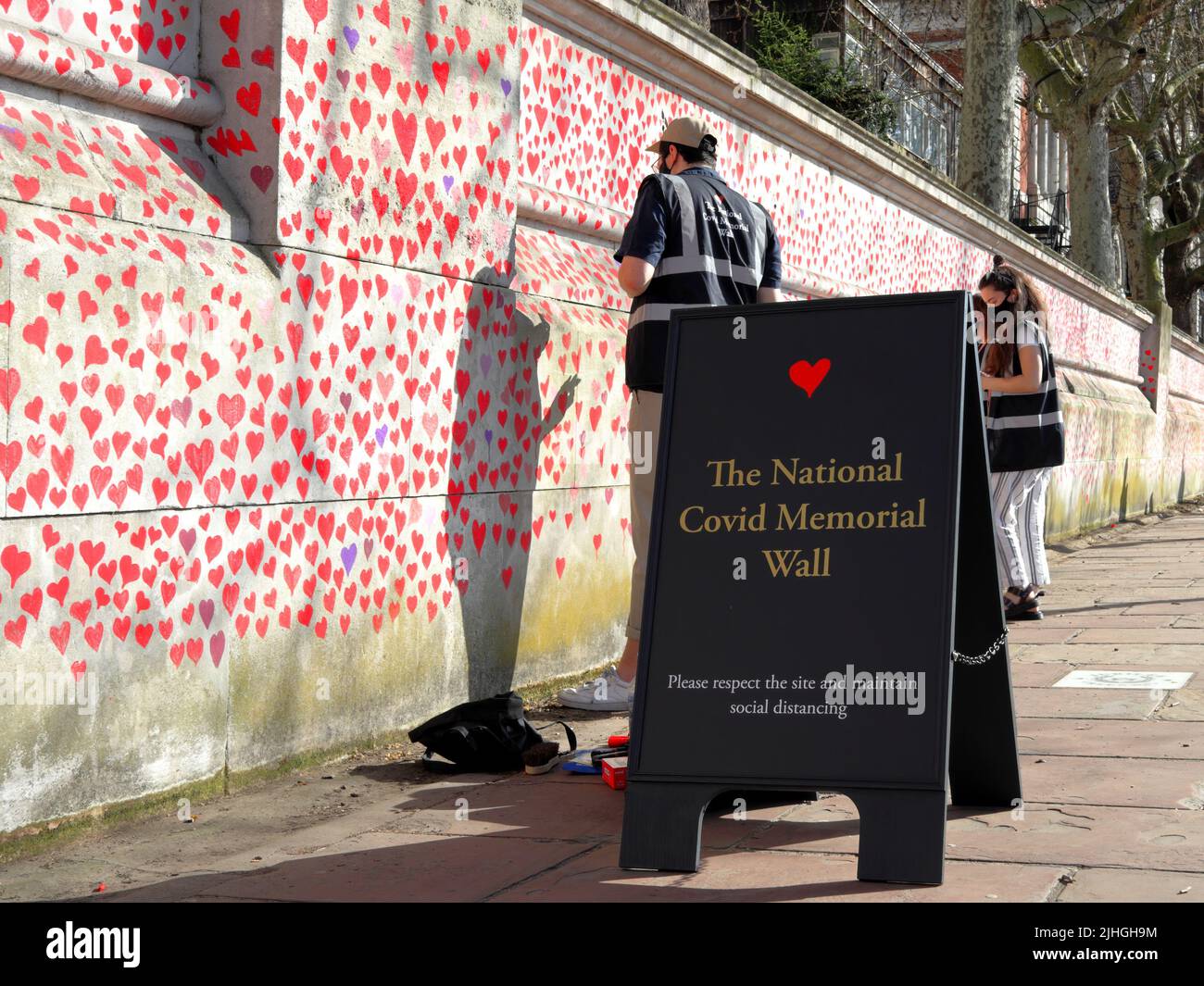 Londres, Reino Unido - 30 de marzo de 2021: El Muro Conmemorativo Nacional de Covid, voluntarios pintando 150.000 corazones rojos para conmemorar las muertes de Covid-19 Foto de stock