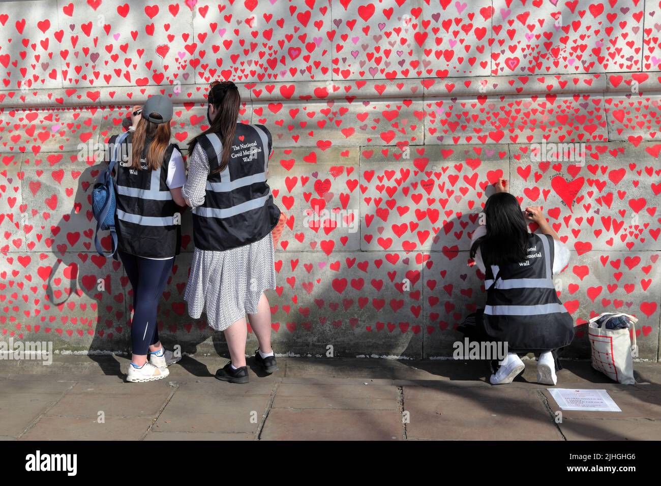 Londres, Reino Unido - 30 de marzo de 2021: El Muro Conmemorativo Nacional de Covid, voluntarios pintando 150.000 corazones rojos para conmemorar las muertes de Covid-19 Foto de stock