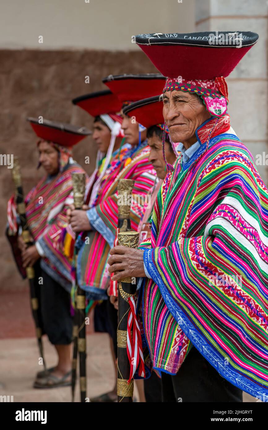 Hombres quechua ('varayocs' o alcaldes locales) vestidos con trajes tradicionales fuera de la iglesia, Pisac, Cusco, Perú Foto de stock