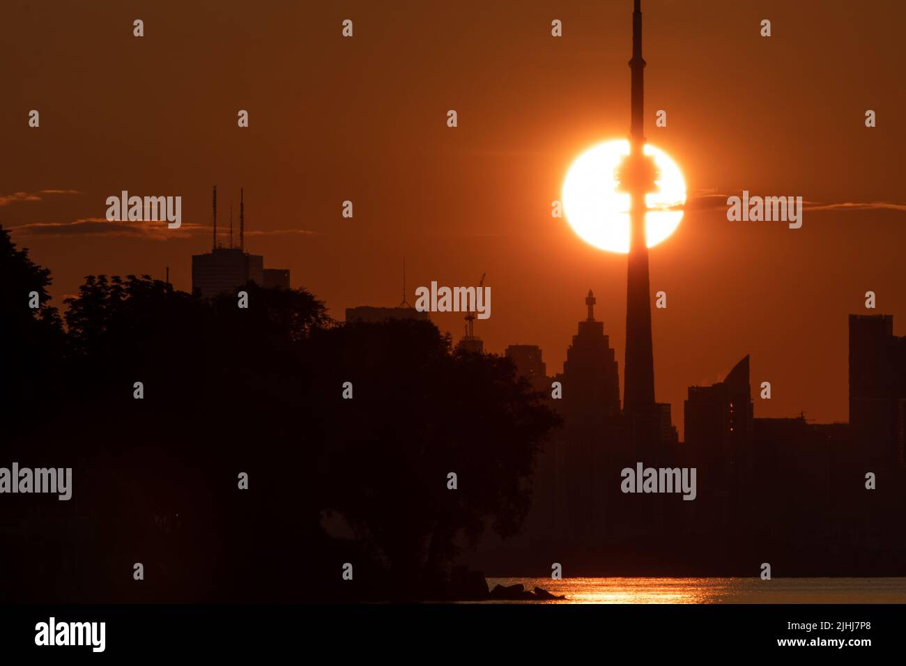 La icónica silueta del horizonte de Toronto se ve a primera hora de la mañana mientras el sol pasa al fondo de la Torre CN. Foto de stock