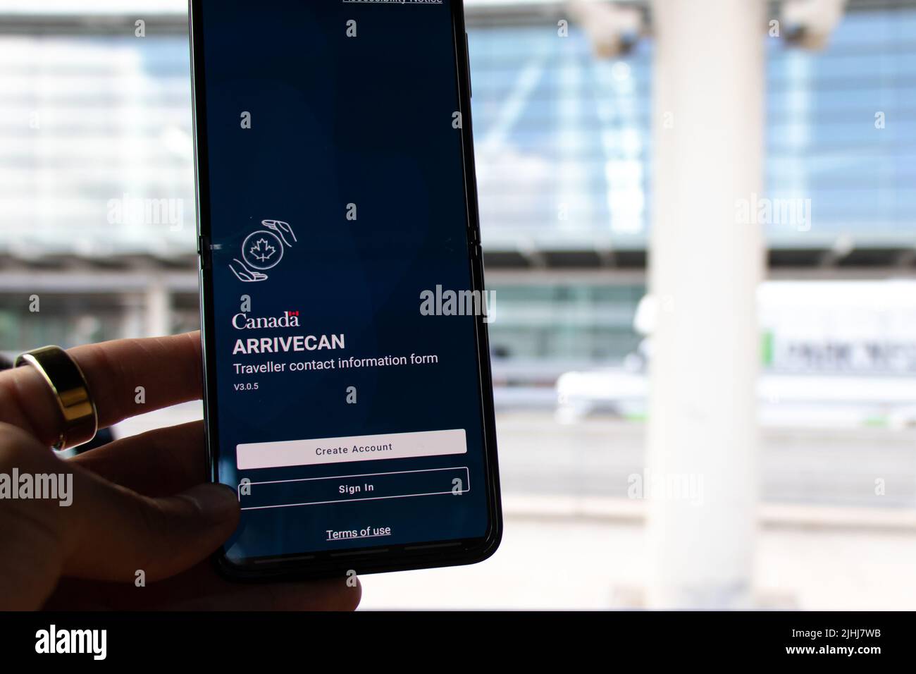 Se ve a un pasajero en Toronto Pearson con un smartphone con la aplicación ArriveCAN en pantalla, utilizada para entrar en Canadá durante la pandemia COVID-19. Foto de stock