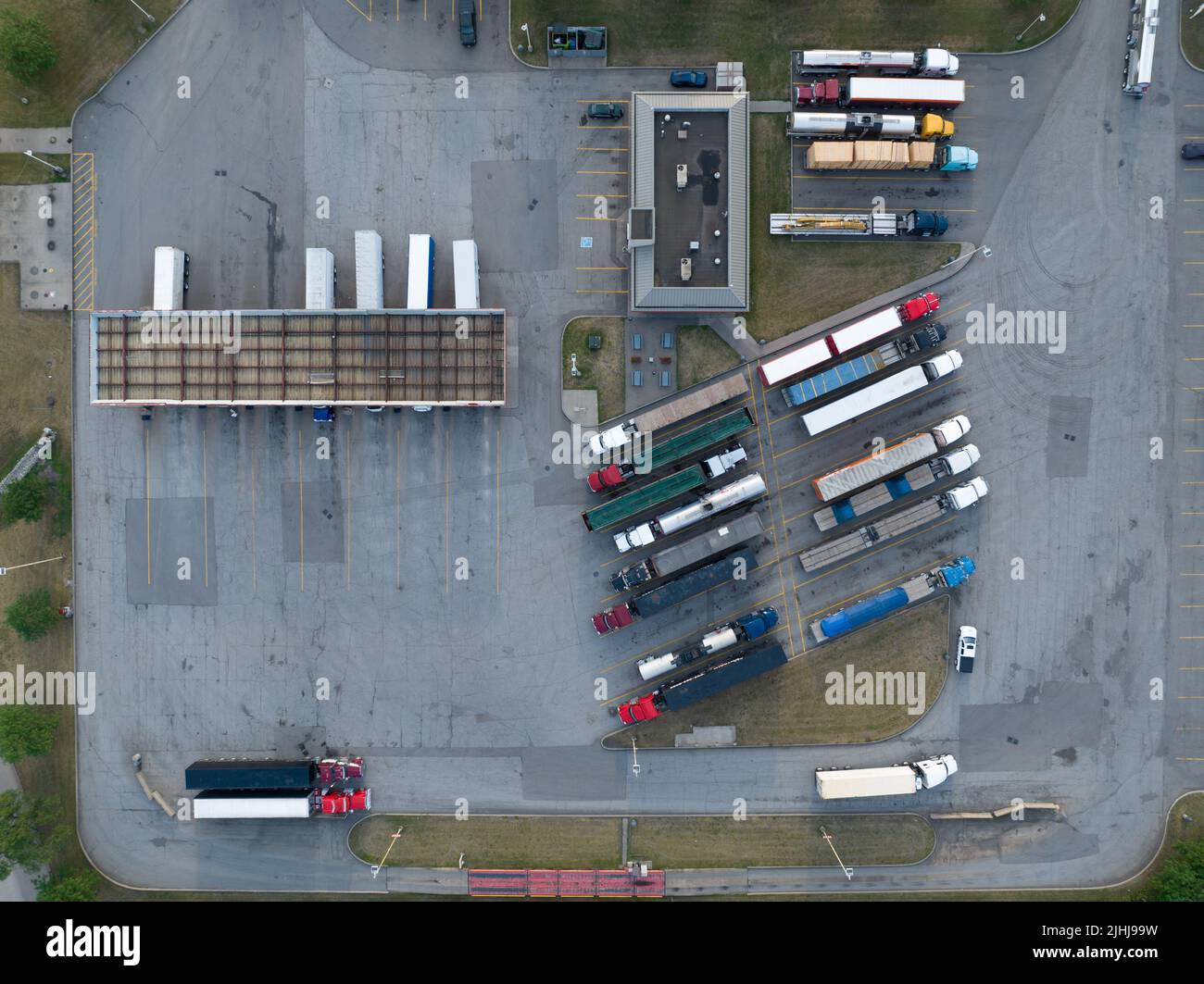 Una vista aérea directa sobre una gran gasolinera de transporte y camiones que se ven estacionados, durante el día. Foto de stock