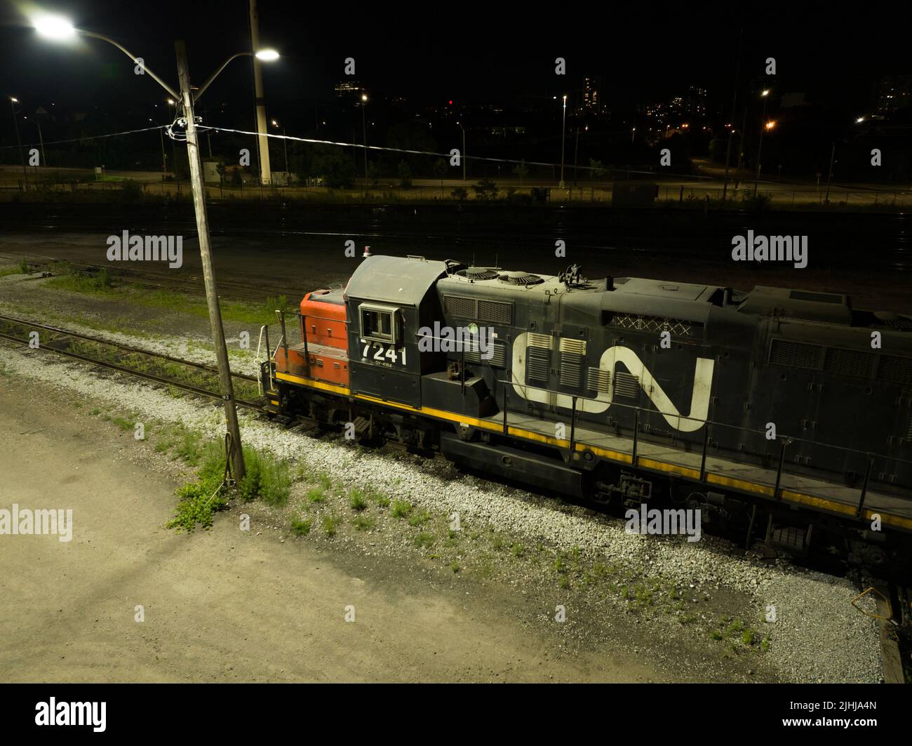 Una locomotora fija CN Rail (Canadian National Railway) se ve de noche con su logotipo iluminado en el lateral del tren. Foto de stock