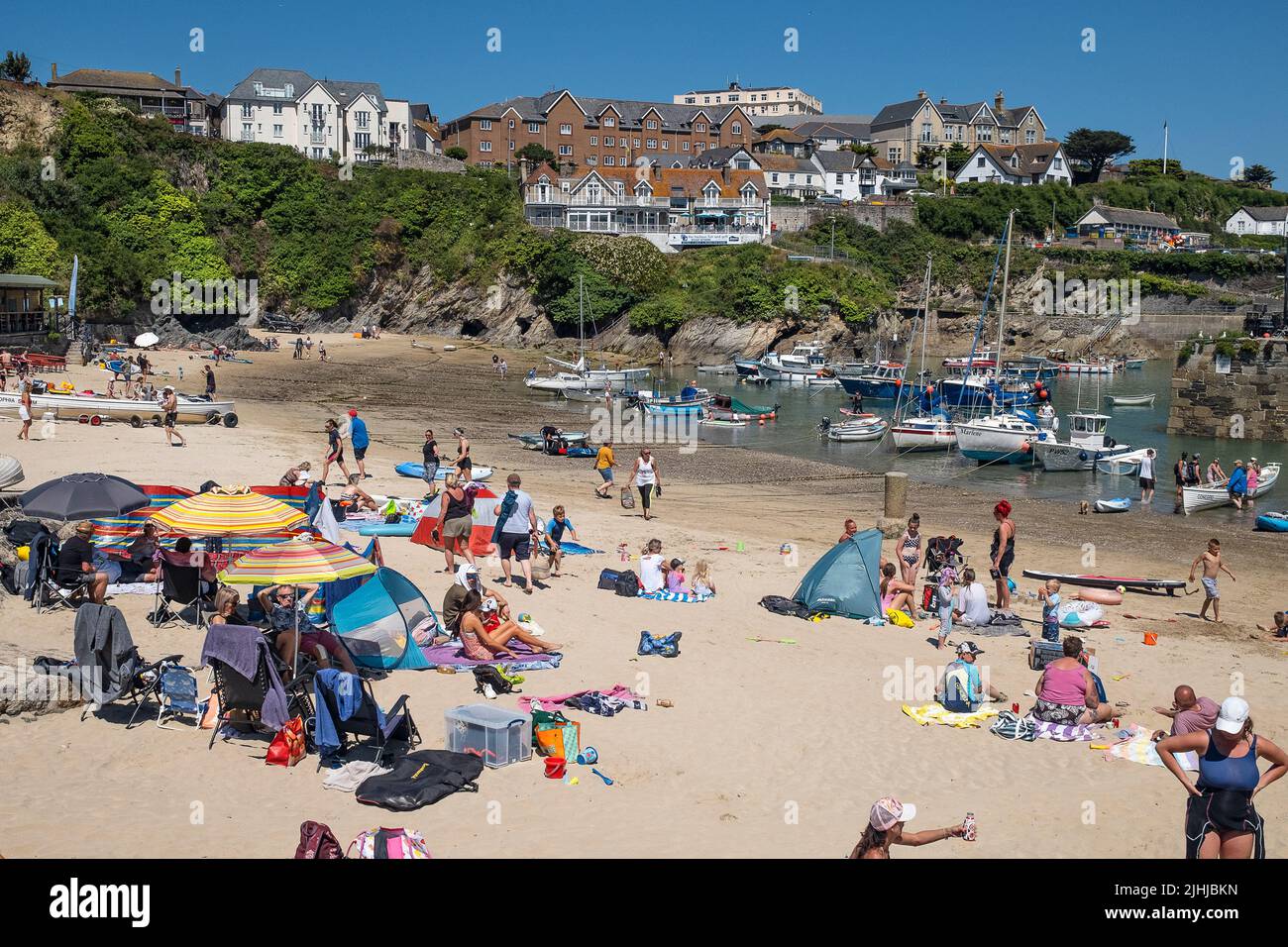 Turistas disfrutando del glorioso sol en una estancia en el pintoresco puerto de Newquay en Cornwall en Inglaterra en el Reino Unido. Foto de stock
