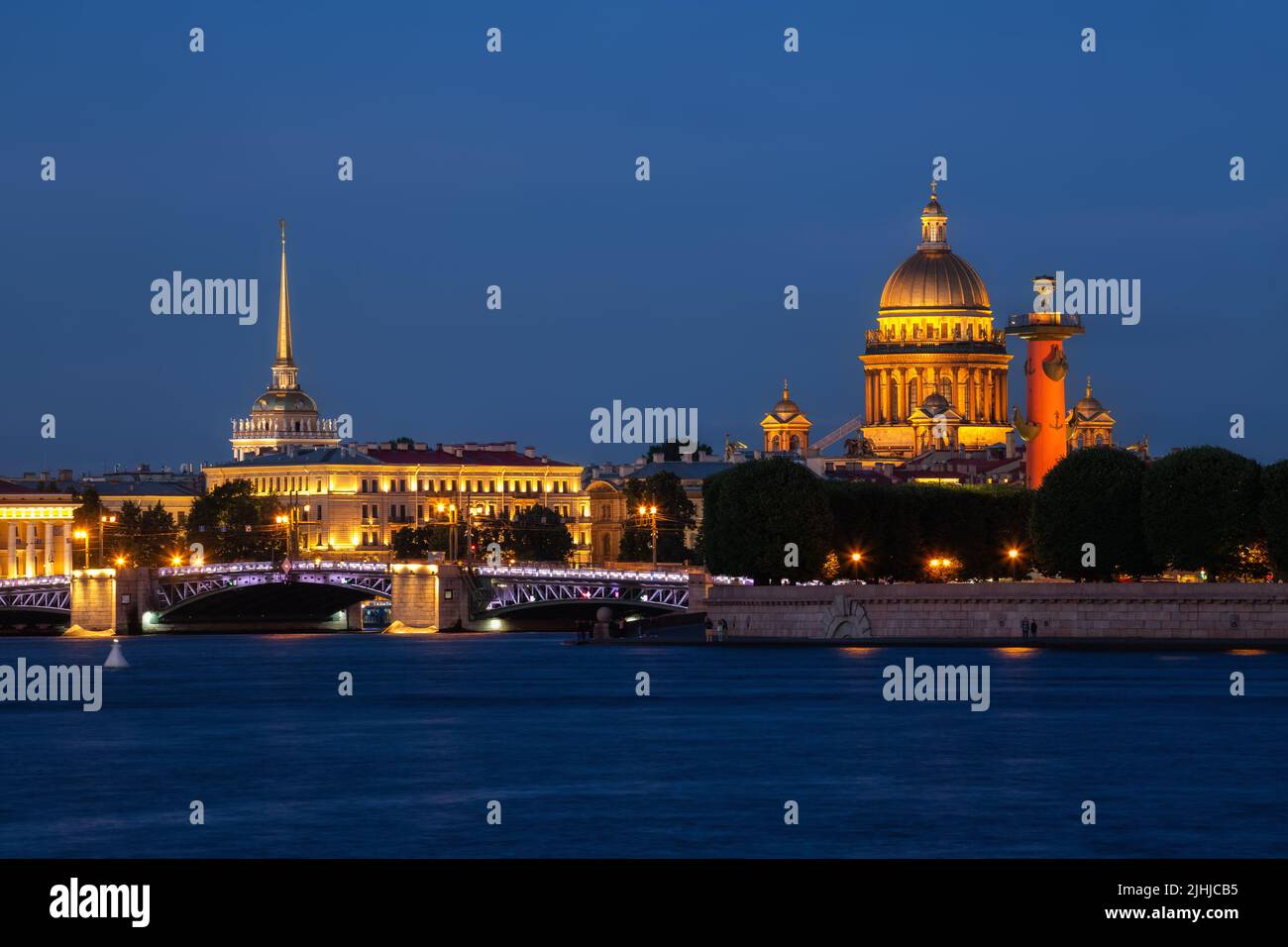 Noche blanca de verano en San Petersburgo. Vista del puente del palacio iluminado, la catedral de San Isaac y la aguja del almirantazgo Foto de stock