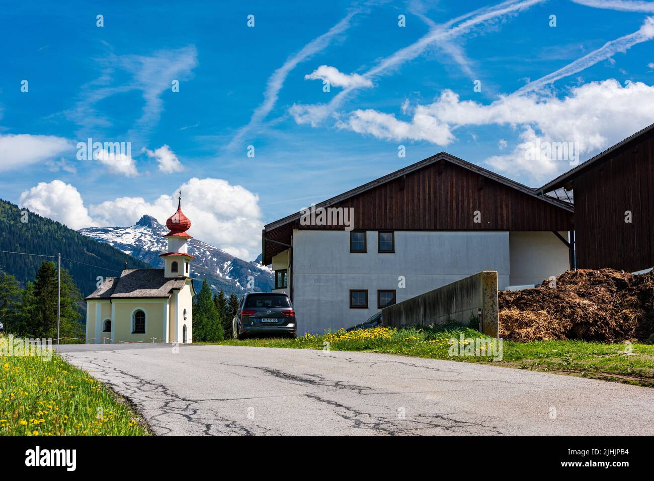 Ein Bauernhof und eine Kirche in den Österreichischen Alpen Foto de stock