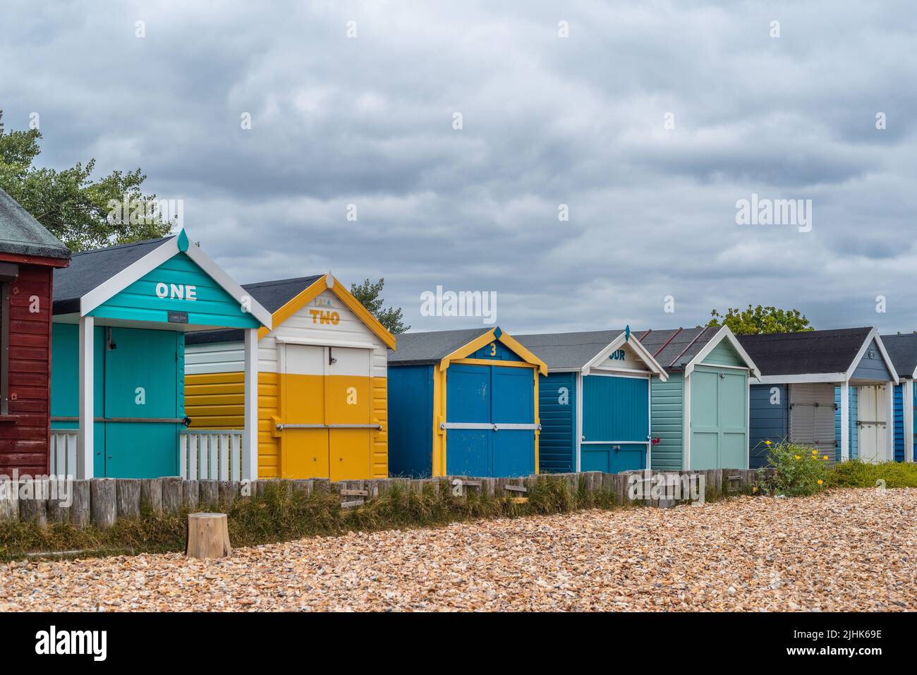 Coloridas cabañas de playa numeradas a lo largo de Calshot Beach, Calshot, Hampshire, Inglaterra, Reino Unido Foto de stock