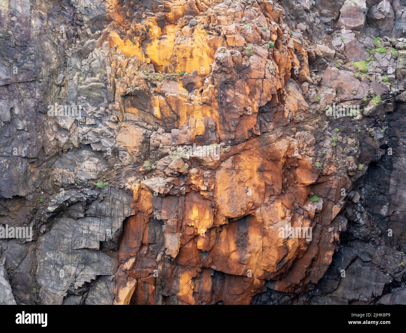 Rocas de color naranja en los agujeros de Scraada, una cueva marina colapsada en Esha Ness, Shetland, Escocia, Reino Unido. Foto de stock