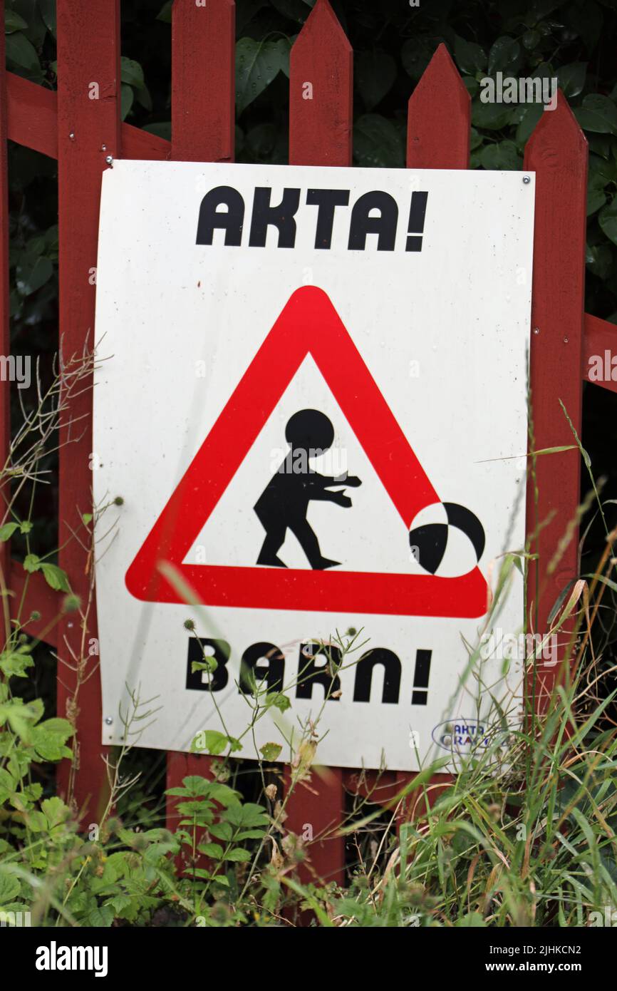 Niños jugando pelota en la calle señal de precaución en Suecia Foto de stock