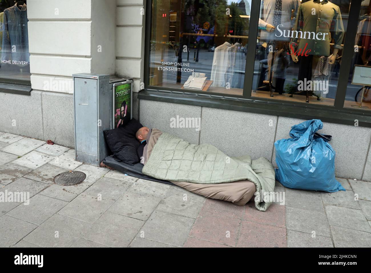 Hombre sin hogar durmiendo en la calle de Estocolmo Foto de stock