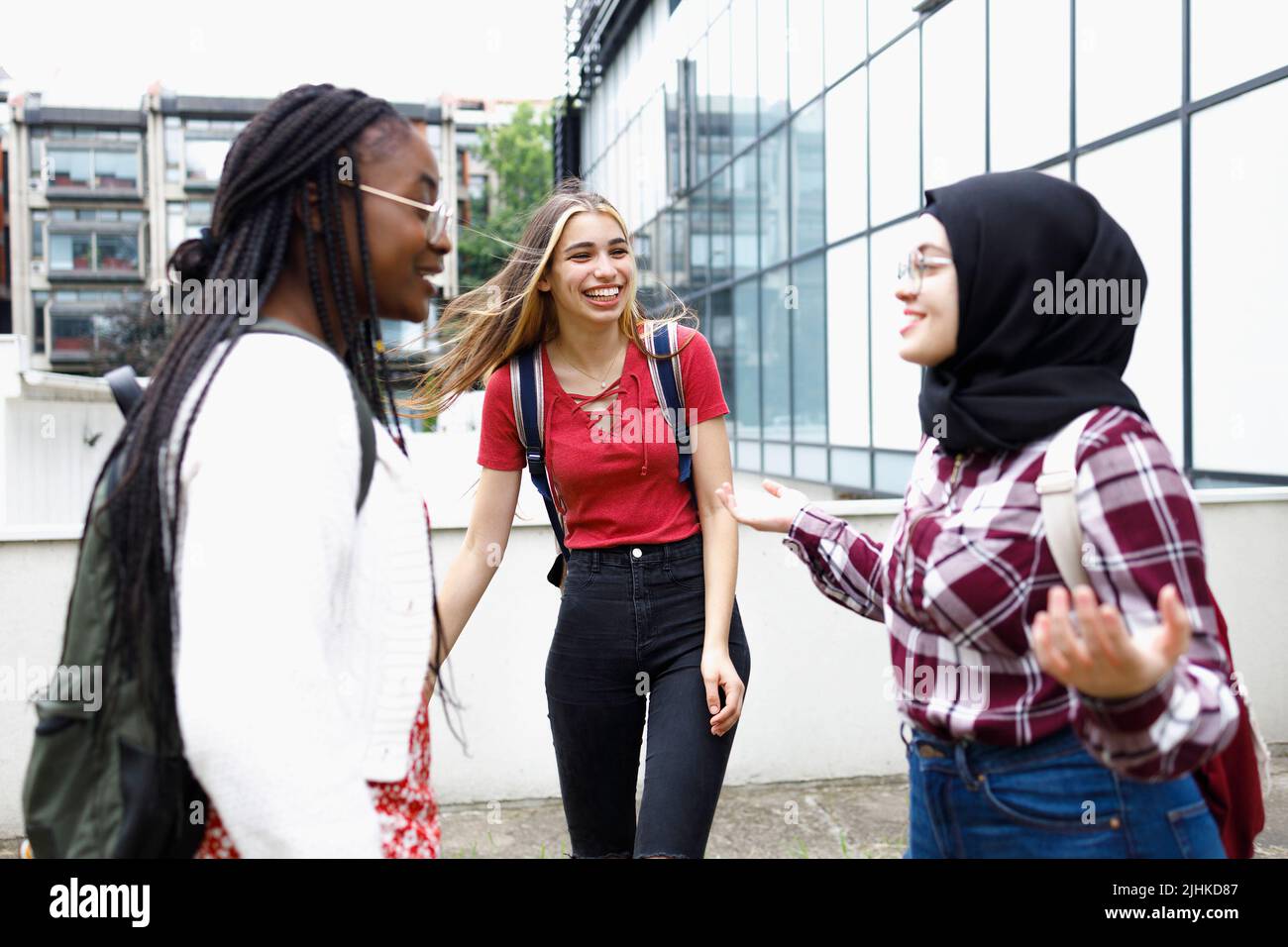 Amigos multiculturales disfrutando de su descanso en el campus Foto de stock
