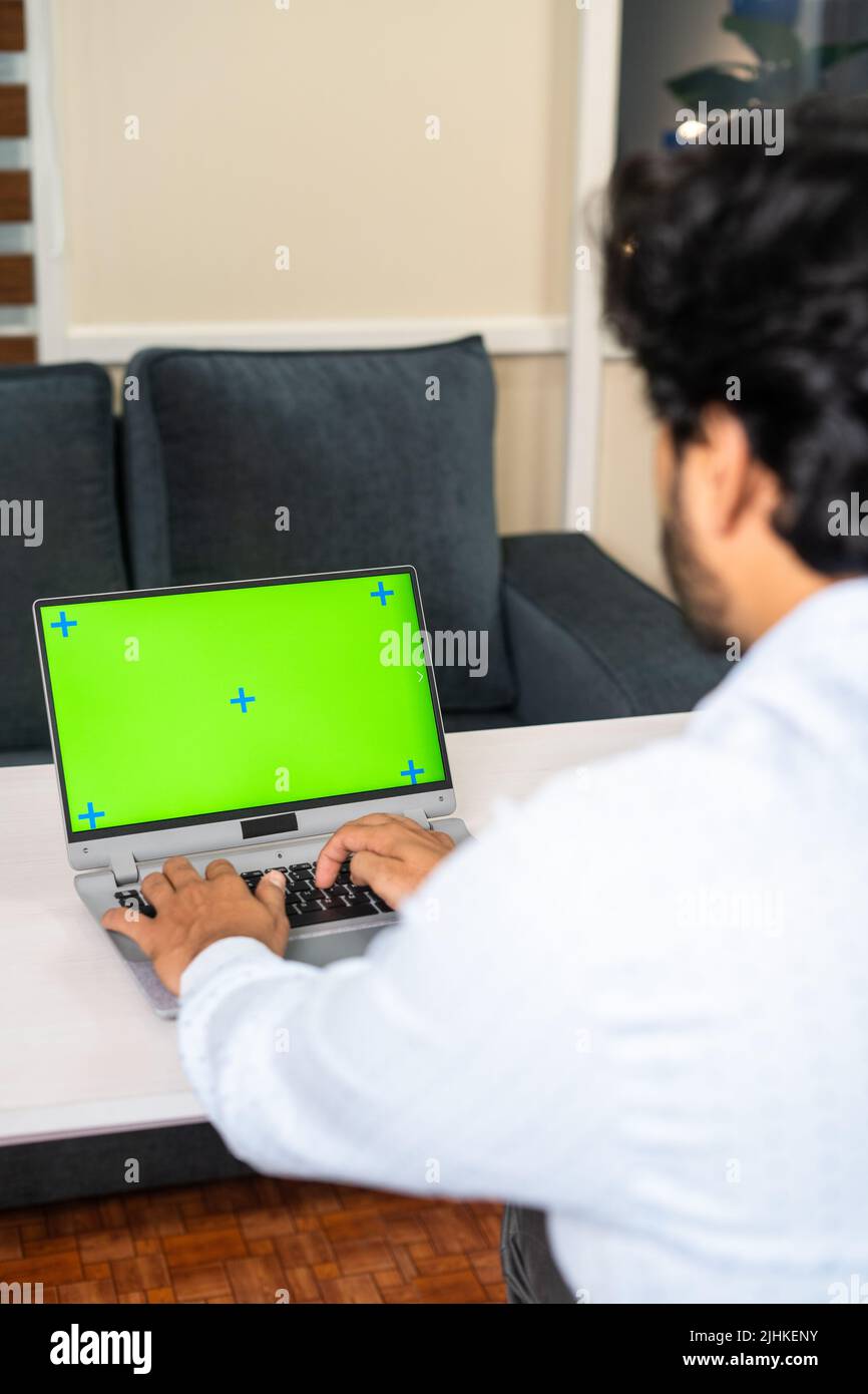 Vertical shoudler foto de empleado corporativo ocupado trabajando en el portátil con pantalla verde maqueta para arriba - concepto de desarrollador de software, trabajo de collar blanco y. Foto de stock