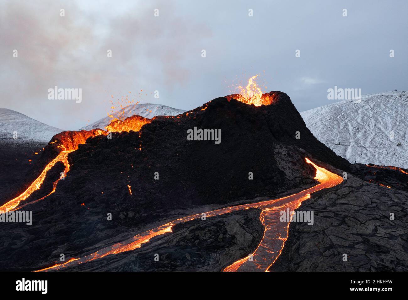 Islandia volcán en erupción en invierno, lava río que fluye de los cráteres Foto de stock