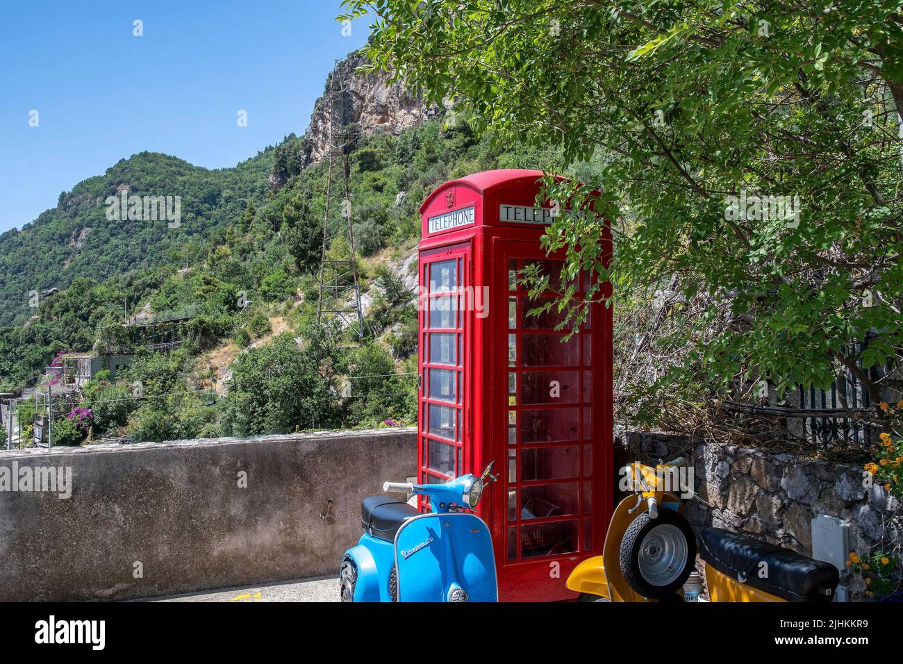 Positano es un pueblo junto al acantilado en la costa de Amalfi, en el sur de Italia. Caja de teléfono británica roja por encima del pueblo Foto de stock