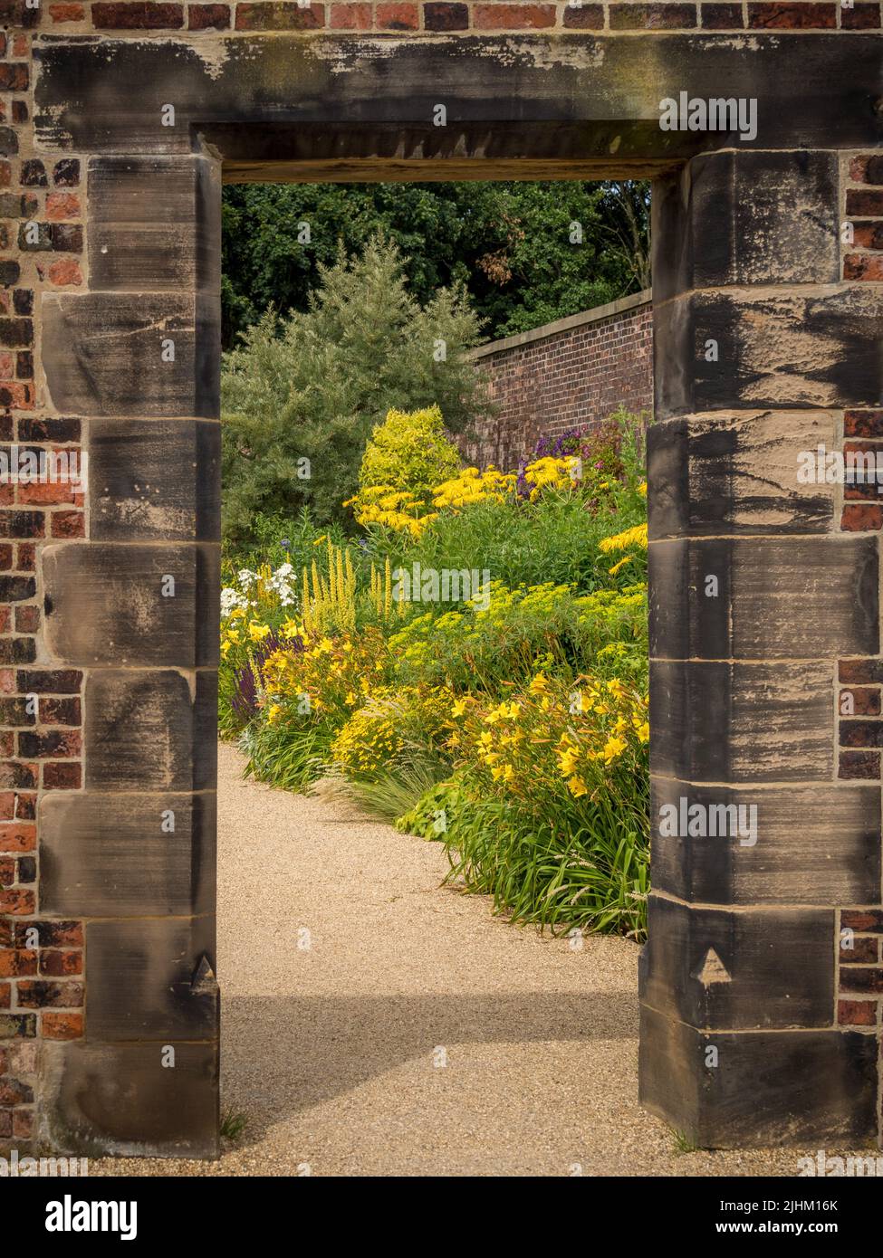 Mirando a través de una abertura en la pared en el jardín del paraíso de RHS Bridgewater en Salford. REINO UNIDO Foto de stock
