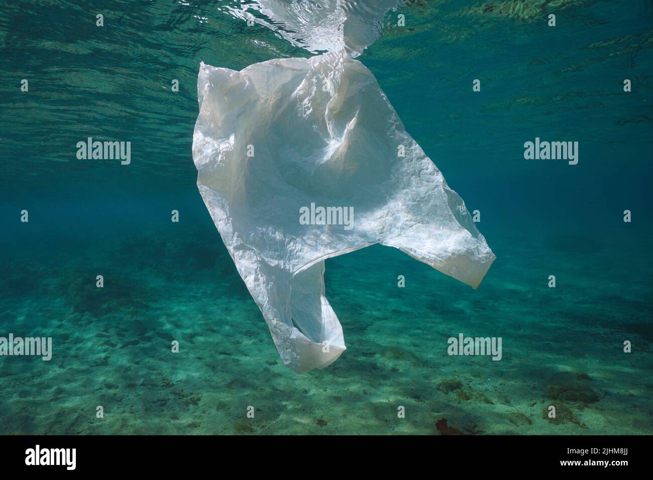 Una bolsa de plástico blanco bajo el agua, contaminación de desechos plásticos en los océanos Foto de stock