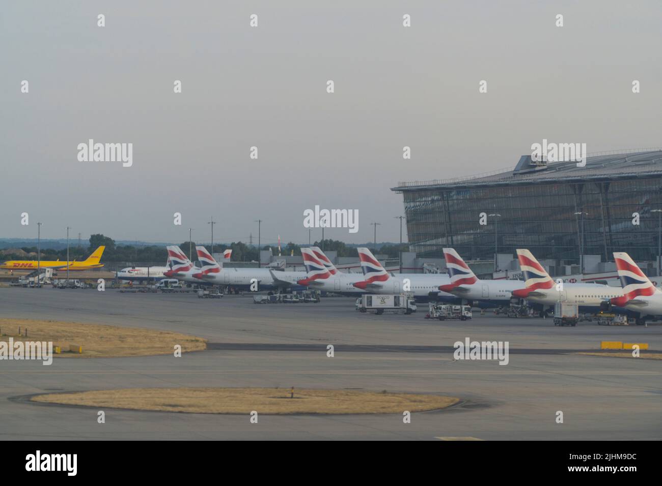 En la terminal 5 del aeropuerto de Heathrow, British Airways tiene aviones alineados en las puertas. Dado que las escuelas estatales están a punto de comenzar sus vacaciones de verano, los aeropuertos sufrirán presión, ya que las familias comienzan sus vacaciones y muchos vuelos ya han sido cancelados debido a la escasez de personal en tierra y en los manipuladores de equipajes de Heathrow y otros aeropuertos. Anna Watson/Alamy Foto de stock